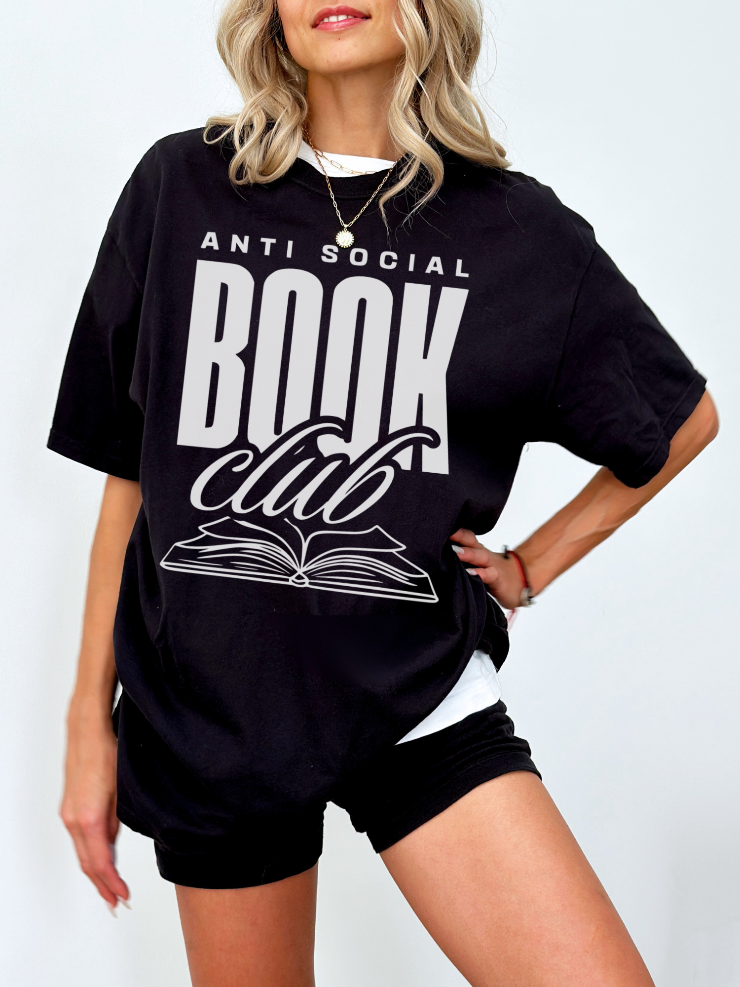 woman in black anti social book club shirt with oversized fit and stacked white lettering with book graphic