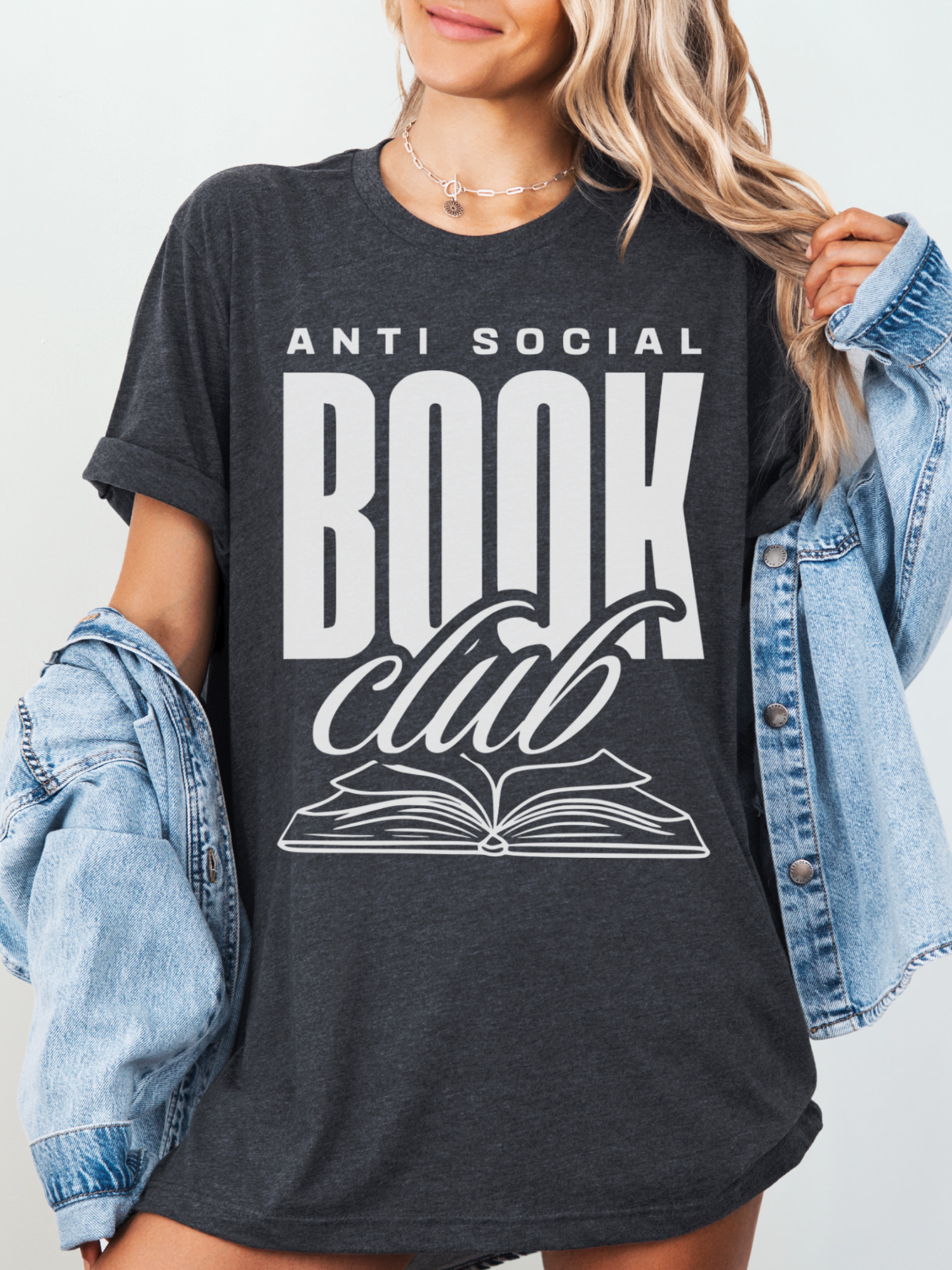 woman wearing a dark grey t-shirt that says anti social book club in bold white text with open book graphic