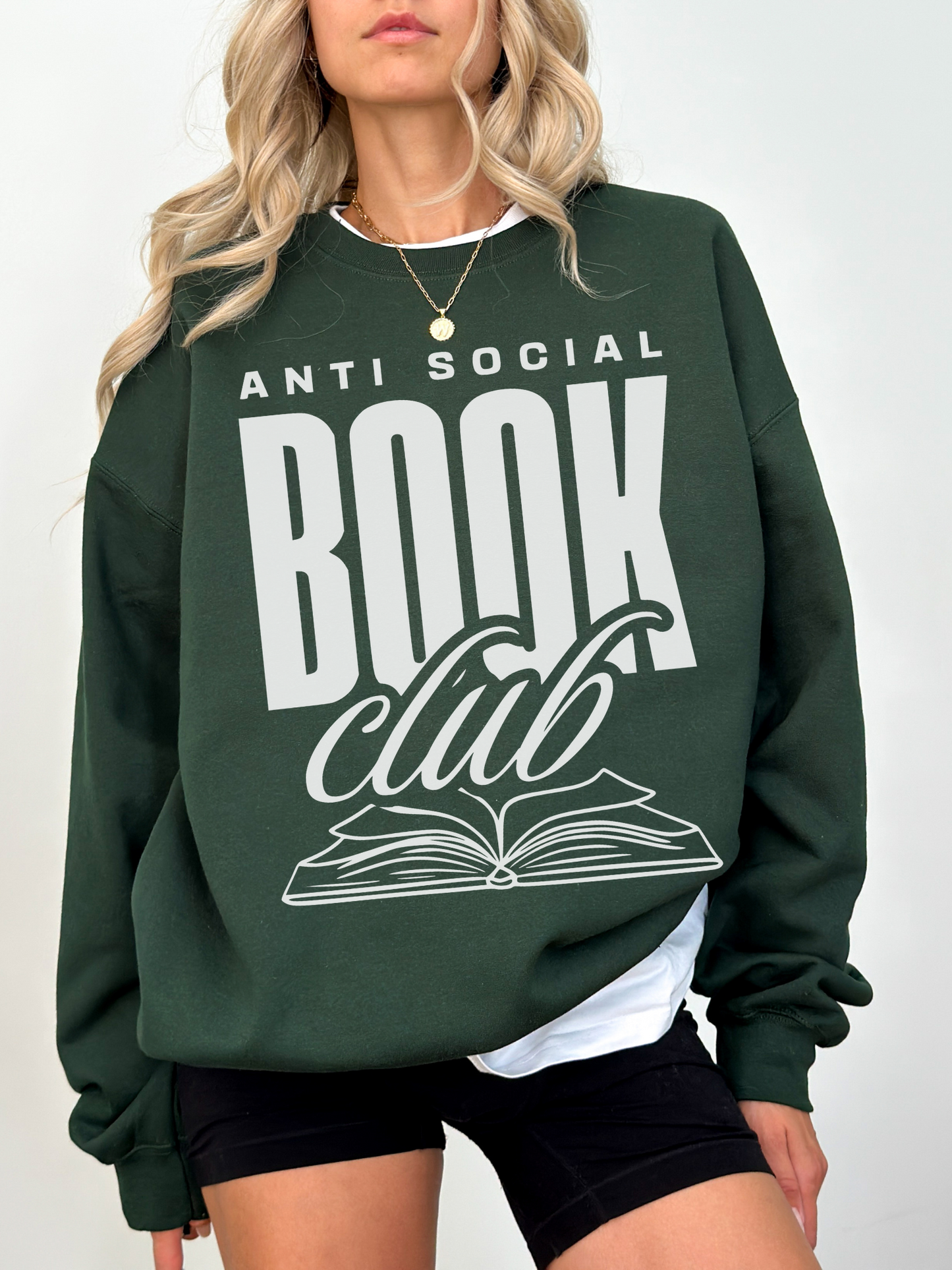 woman in forest green sweatshirt that says anti social book club with bold text and book graphic
