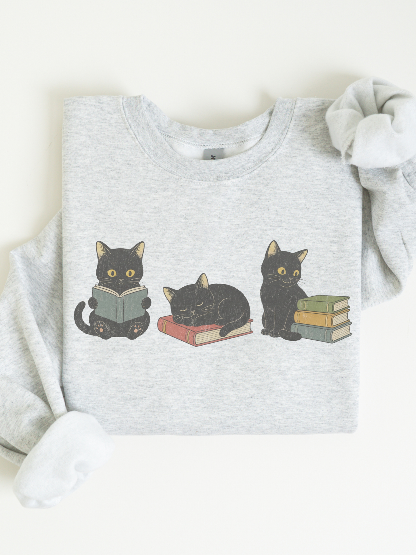 ash grey sweatshirt flat lay featuring three black cats with books including reading sleeping and sitting cats with stacked books perfect for readers librarians and cat lovers
