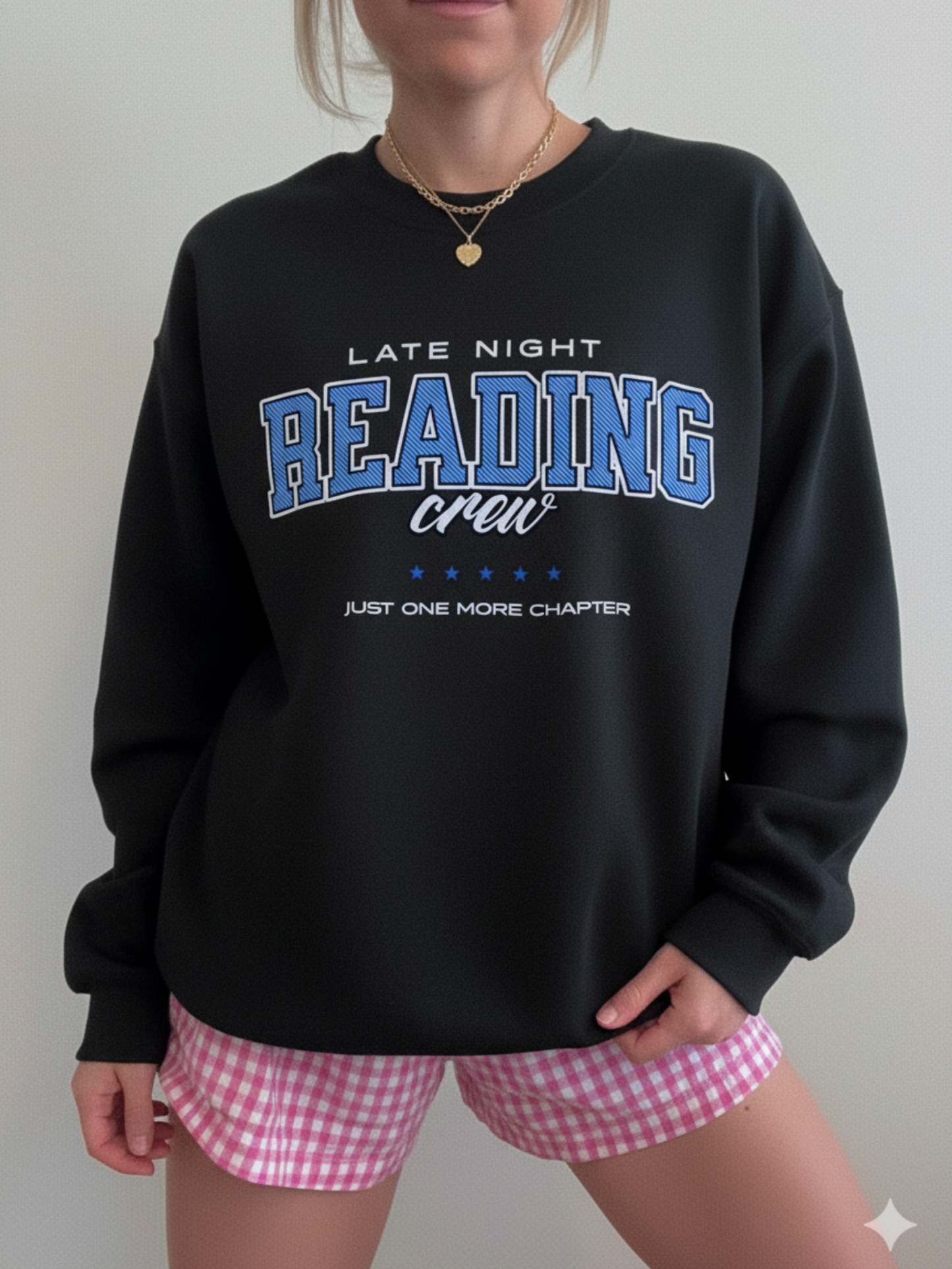 Black bookish sweatshirt with varsity-style “Late Night Reading Crew” graphic, paired with pink checkered pajama shorts