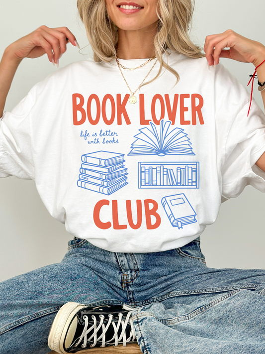 woman wearing a white comfort colors t shirt with book lover club text and blue book illustrations