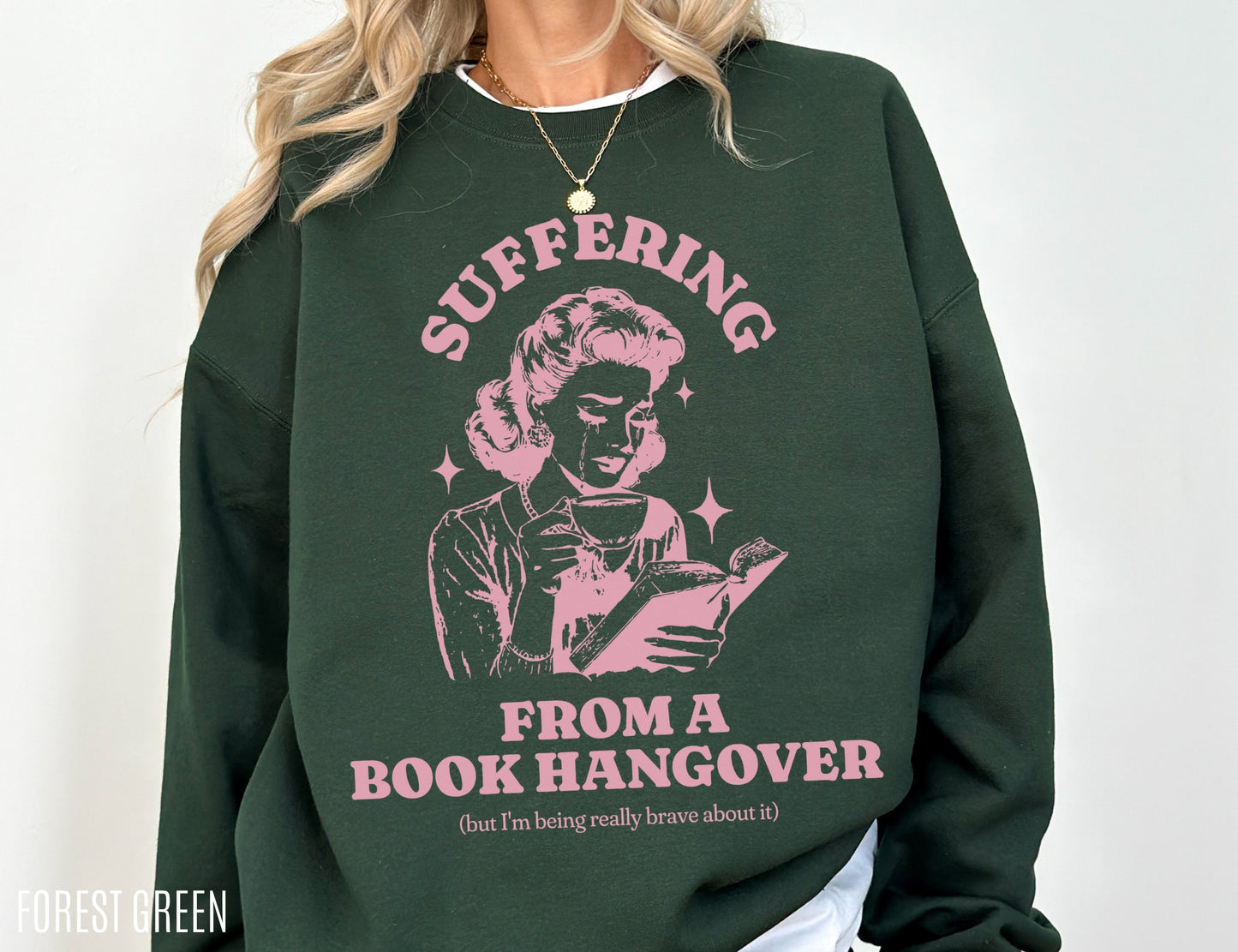 forest green sweatshirt with pink print of retro woman reading and text about book hangover