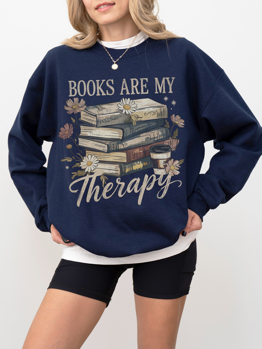cozy navy blue books are my therapy crewneck with stacked vintage books and daisies held by blonde woman