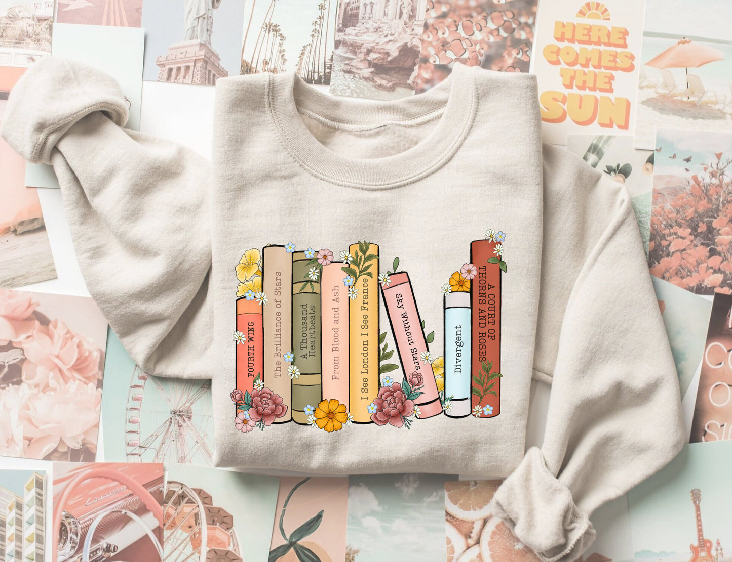 folded sand sweatshirt with pastel book spine design featuring floral fantasy titles like ACOTAR and Fourth Wing