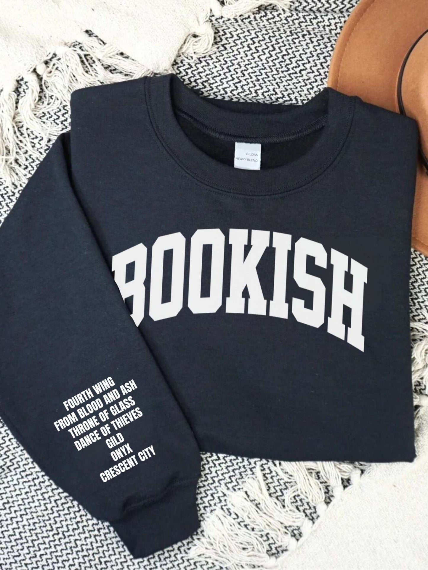 folded black sweatshirt with bold BOOKISH text on front and custom fantasy book list printed vertically on sleeve