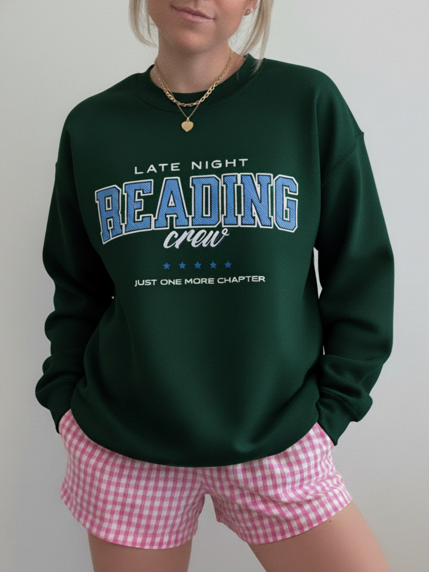 Forest green sweatshirt with vintage “Late Night Reading Crew” print and collegiate vibes, styled with pink gingham shorts.
