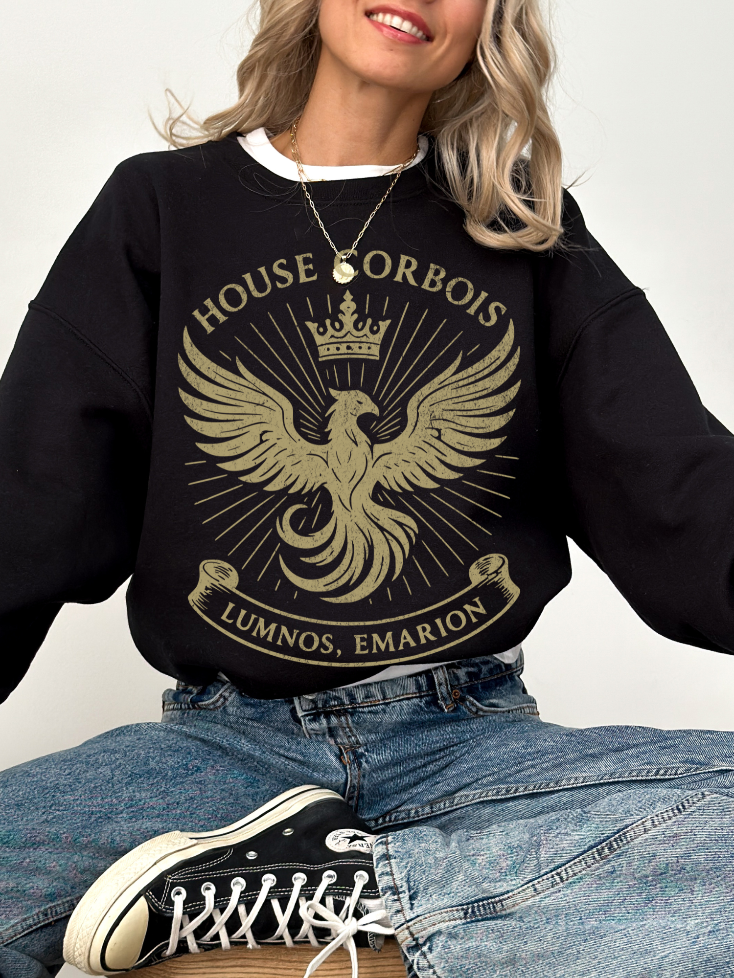 Cozy black sweatshirt with gold House Corbois phoenix crest, worn with jeans and Converse