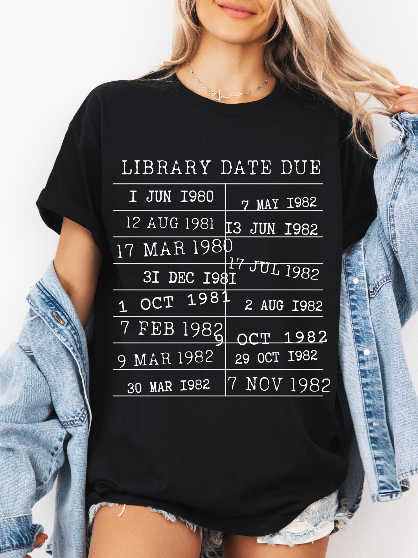 woman wearing a black t-shirt with vintage library stamp and bookish quote, styled with denim jacket