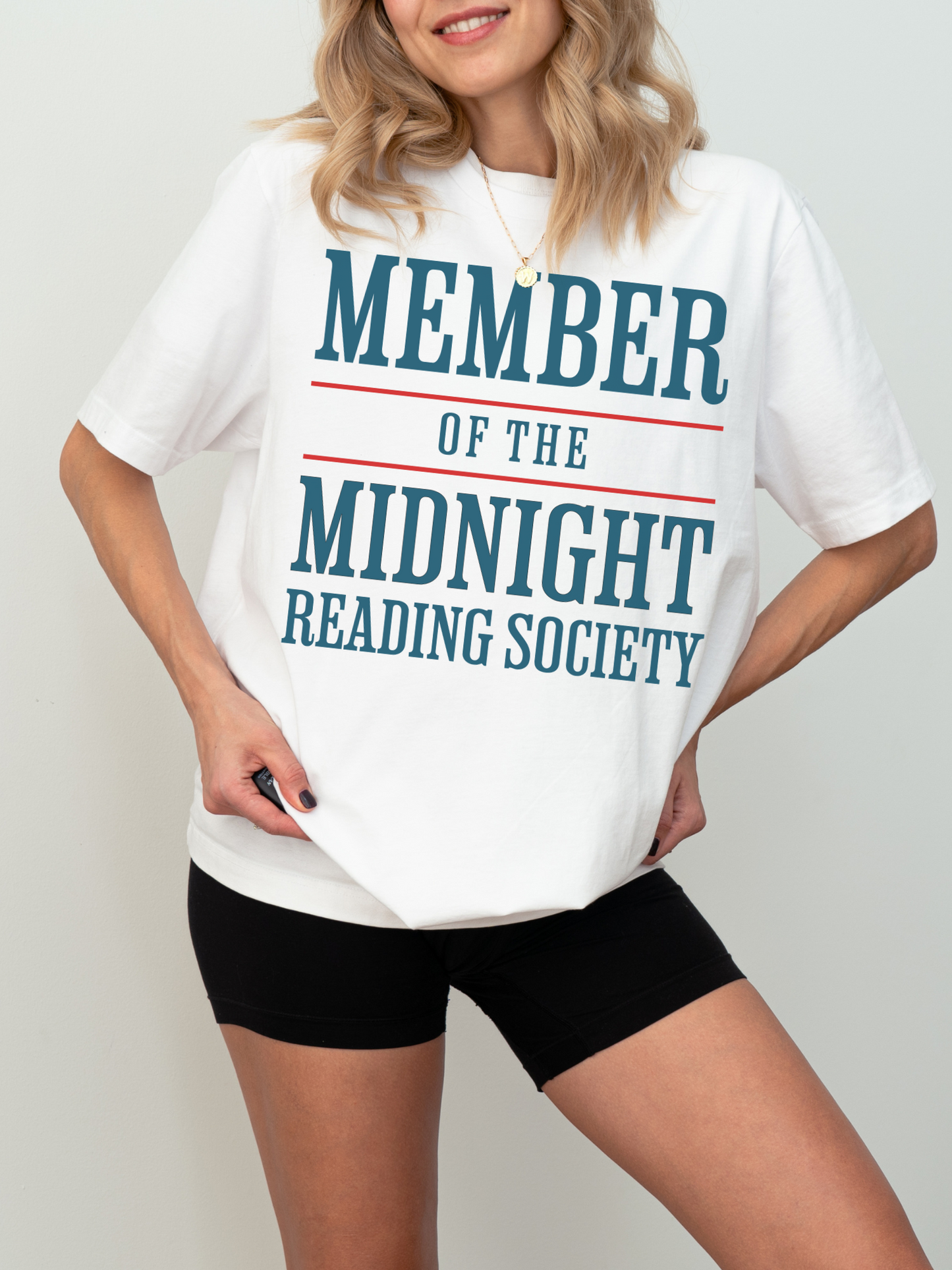 woman in a white oversized shirt with blue and red text that reads member of the midnight reading society