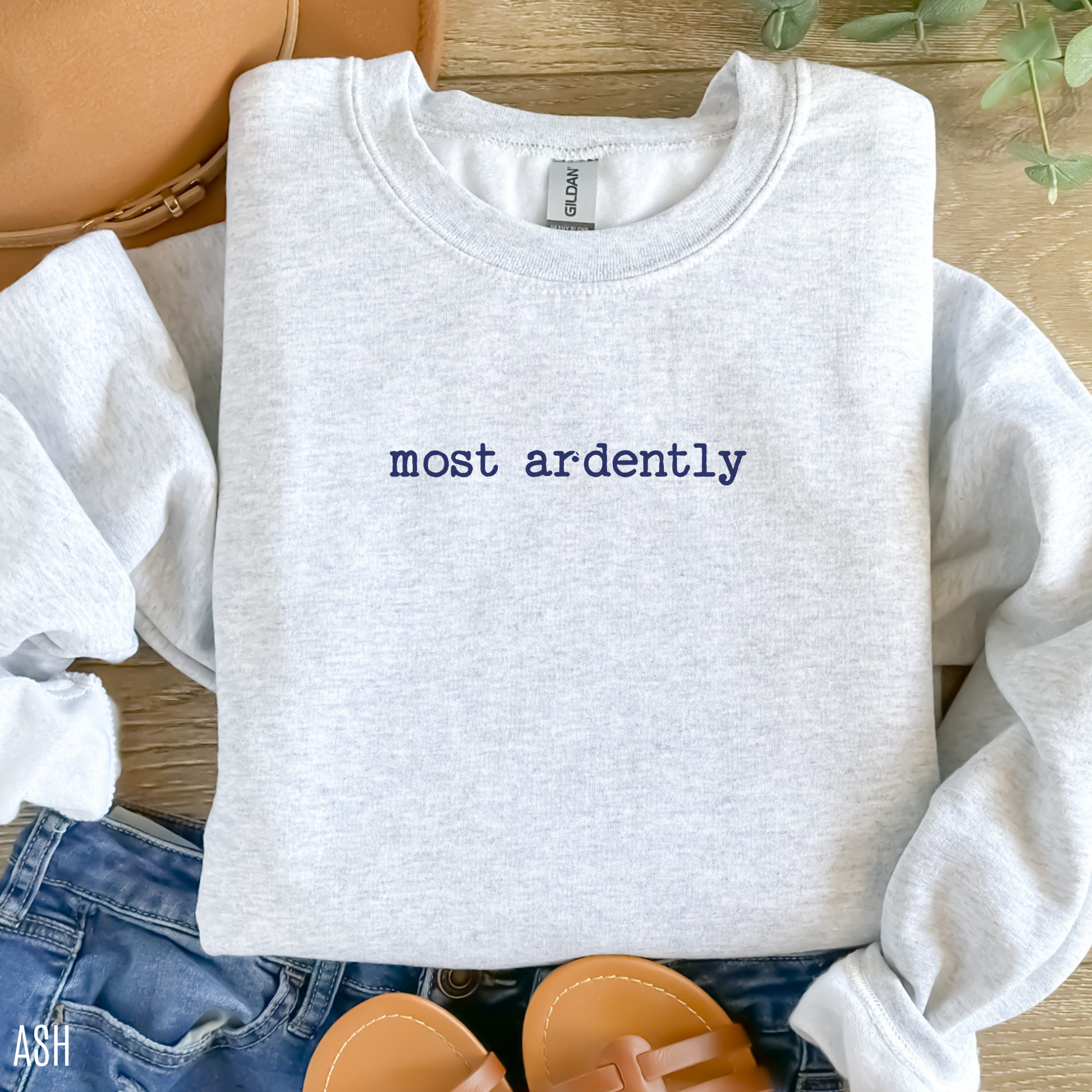 folded ash grey sweatshirt with navy blue most ardently quote styled with jeans and sandals