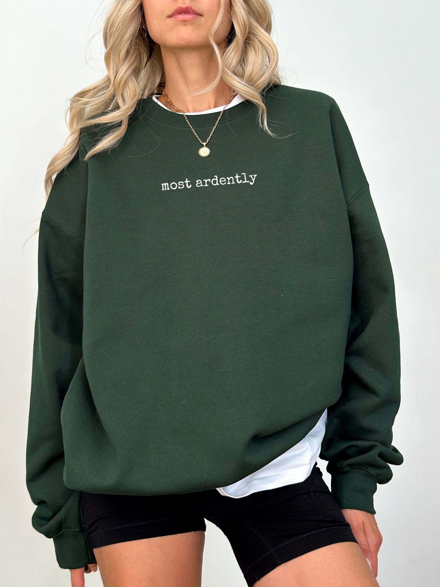 woman wearing forest green sweatshirt with white most ardently quote from Mr. Darcy