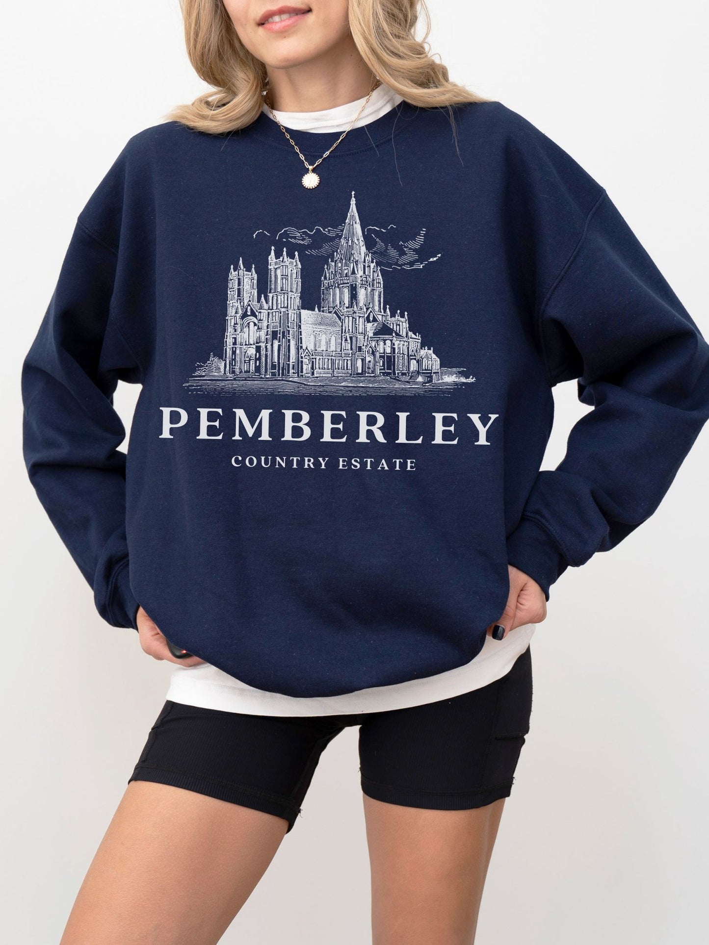 woman wearing navy sweatshirt with vintage Pemberley estate sketch and serif lettering