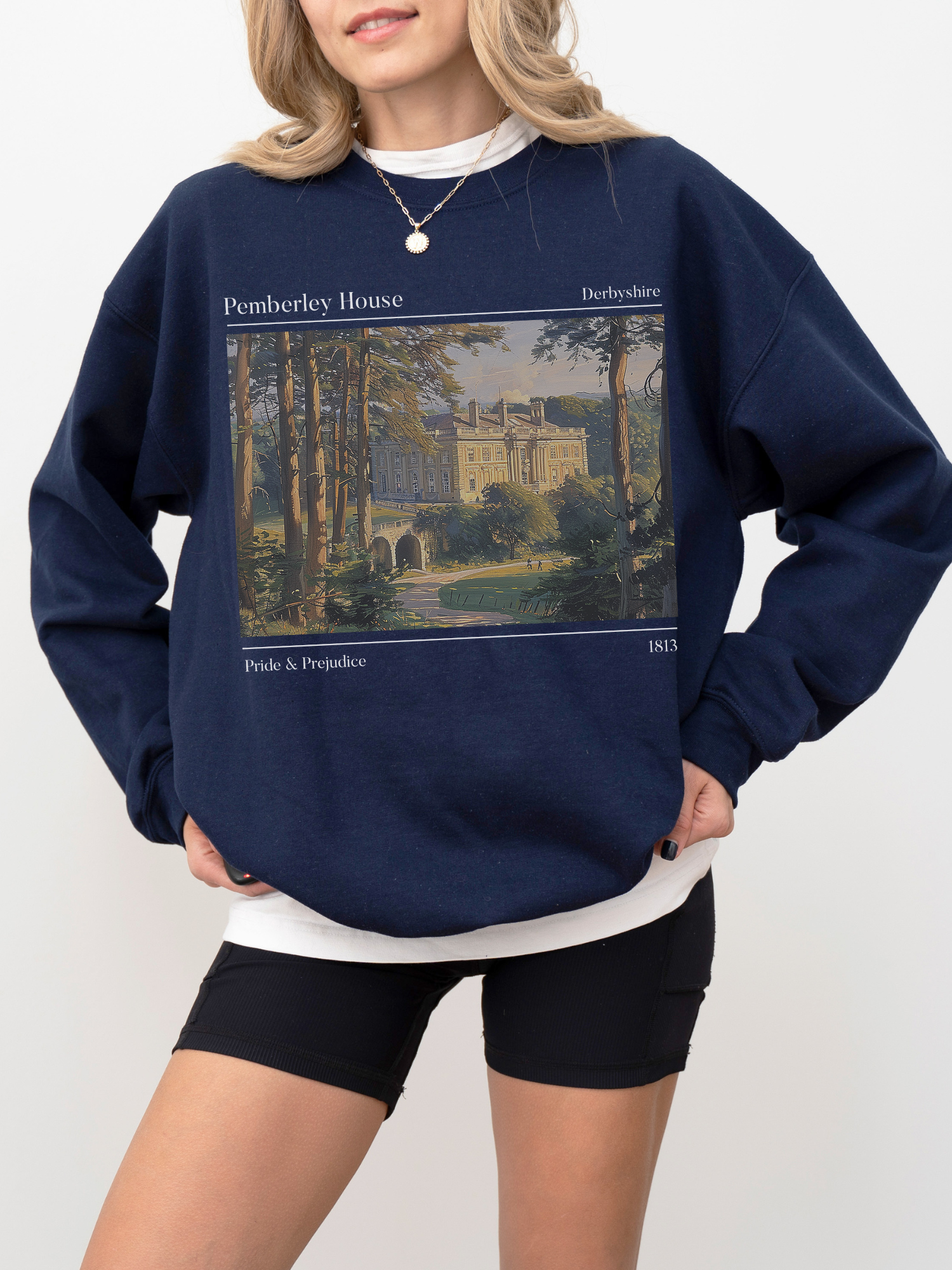 woman in navy Jane Austen sweatshirt featuring illustrated Pemberley estate with text from Pride & Prejudice