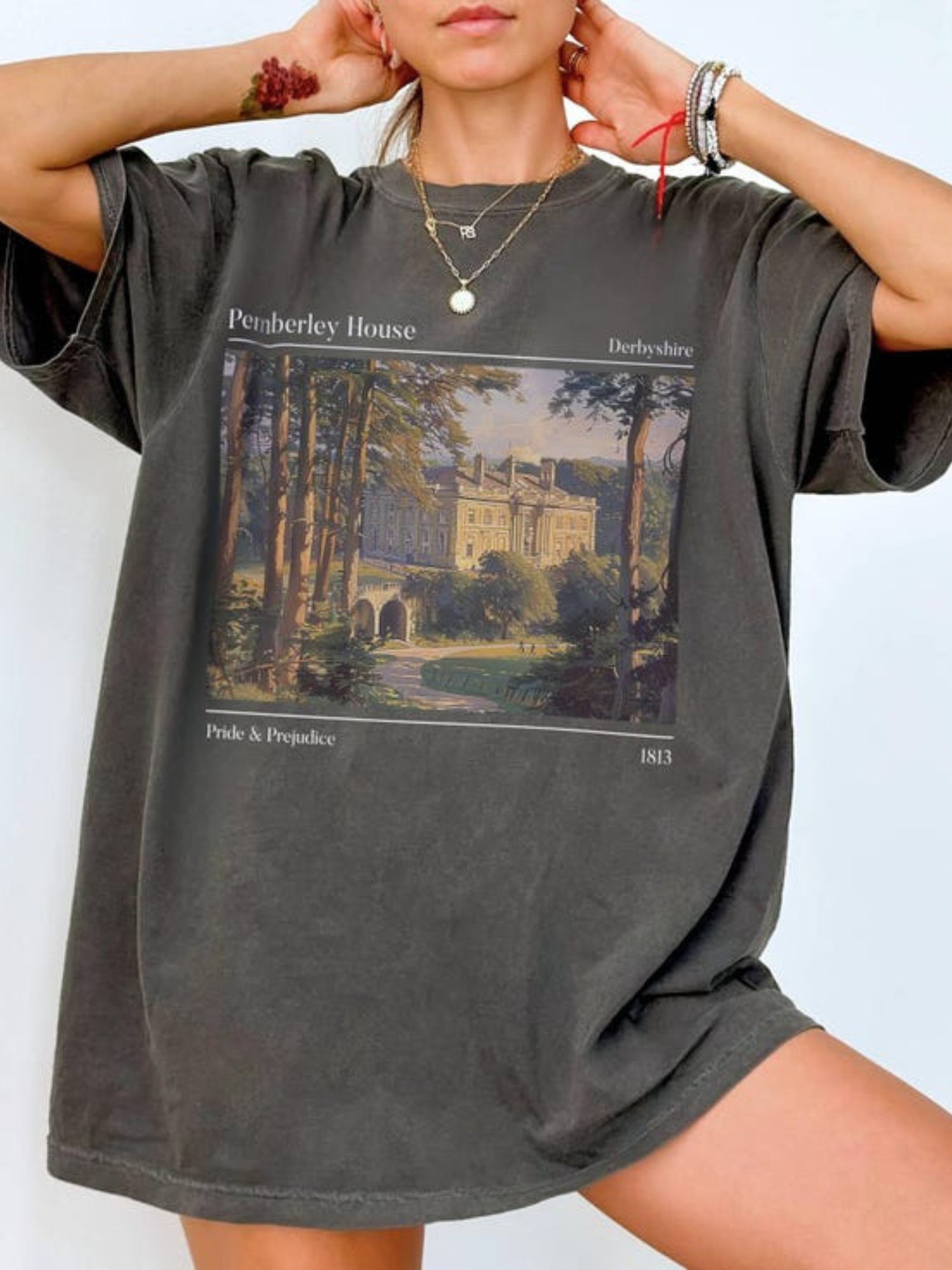 woman in a pepper Pemberley House tee with classic Pride & Prejudice illustration