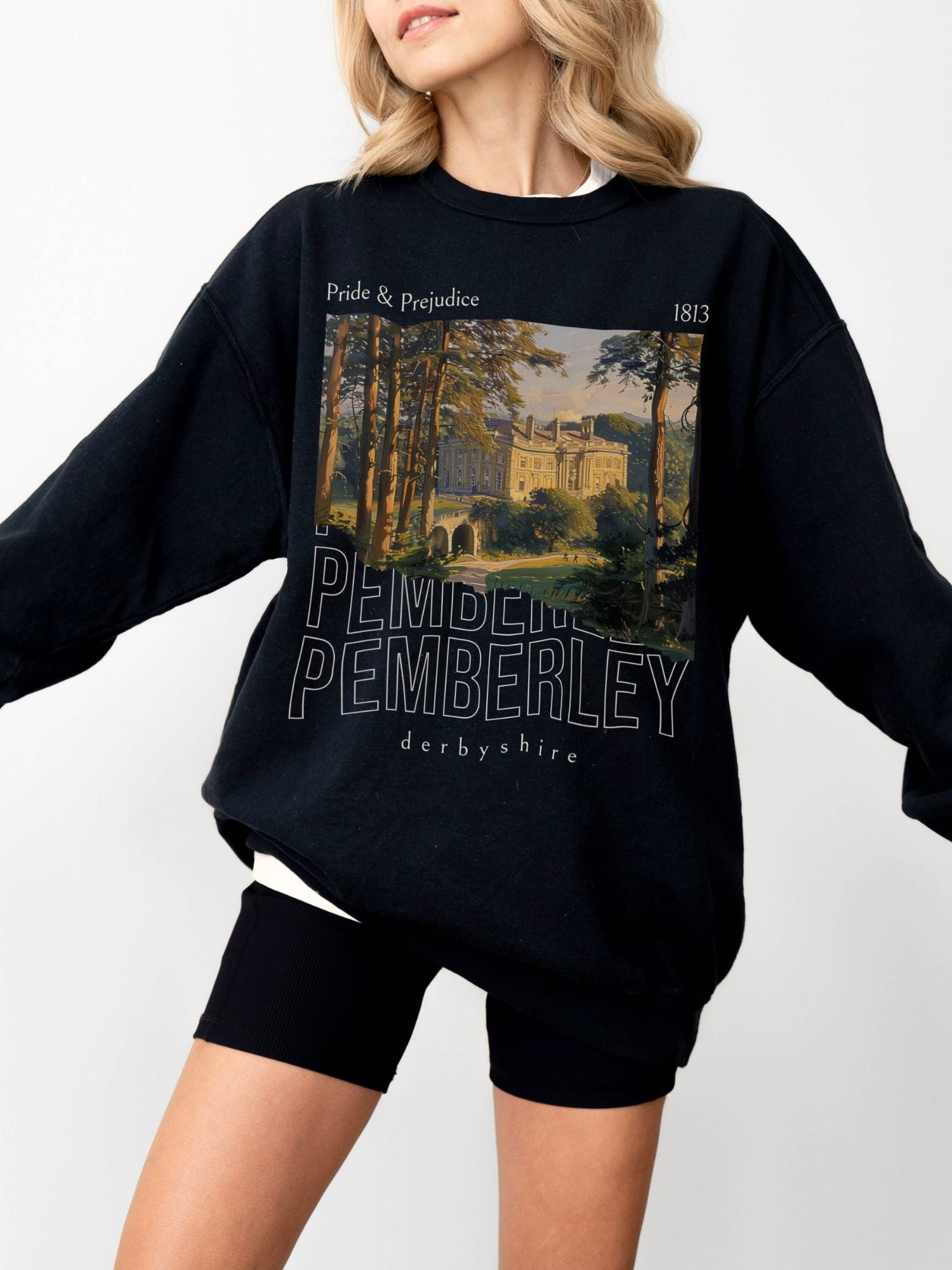 woman wearing black crewneck sweatshirt with Pemberley illustration from Pride and Prejudice and 1813 date
