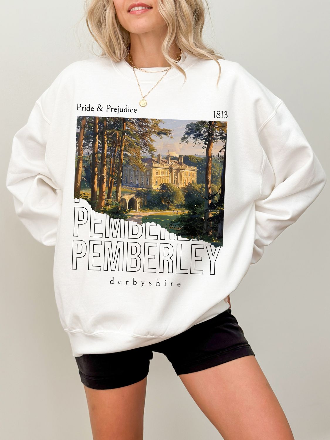 woman wearing white sweatshirt with painting of Pemberley from Pride and Prejudice and Derbyshire text