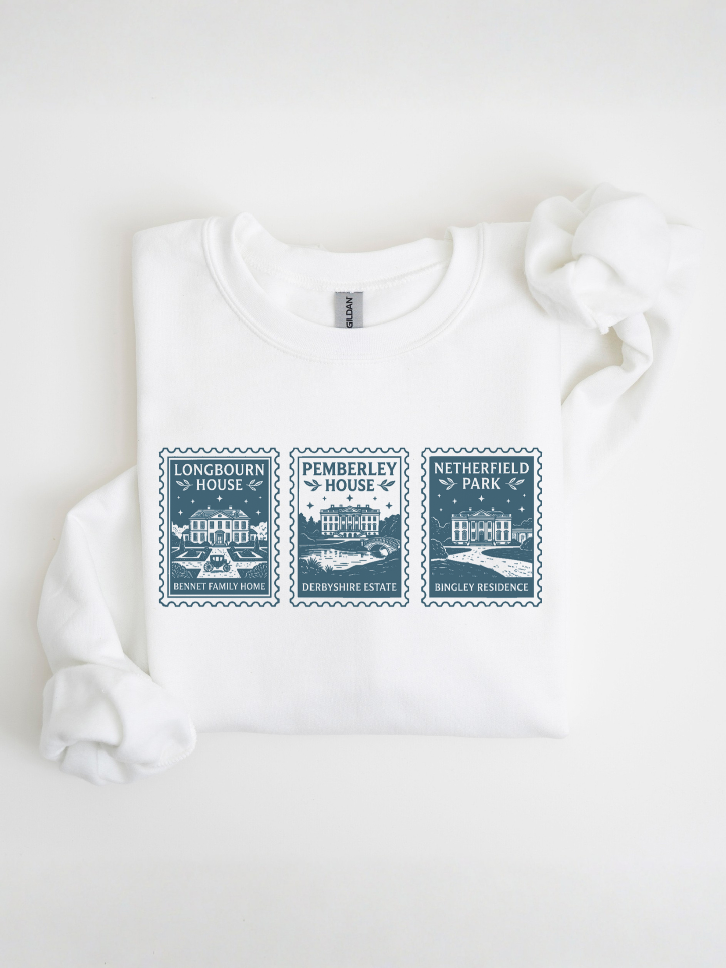 folded white sweatshirt with vintage postage stamp design featuring Longbourn House Pemberley House and Netherfield Park from Pride and Prejudice