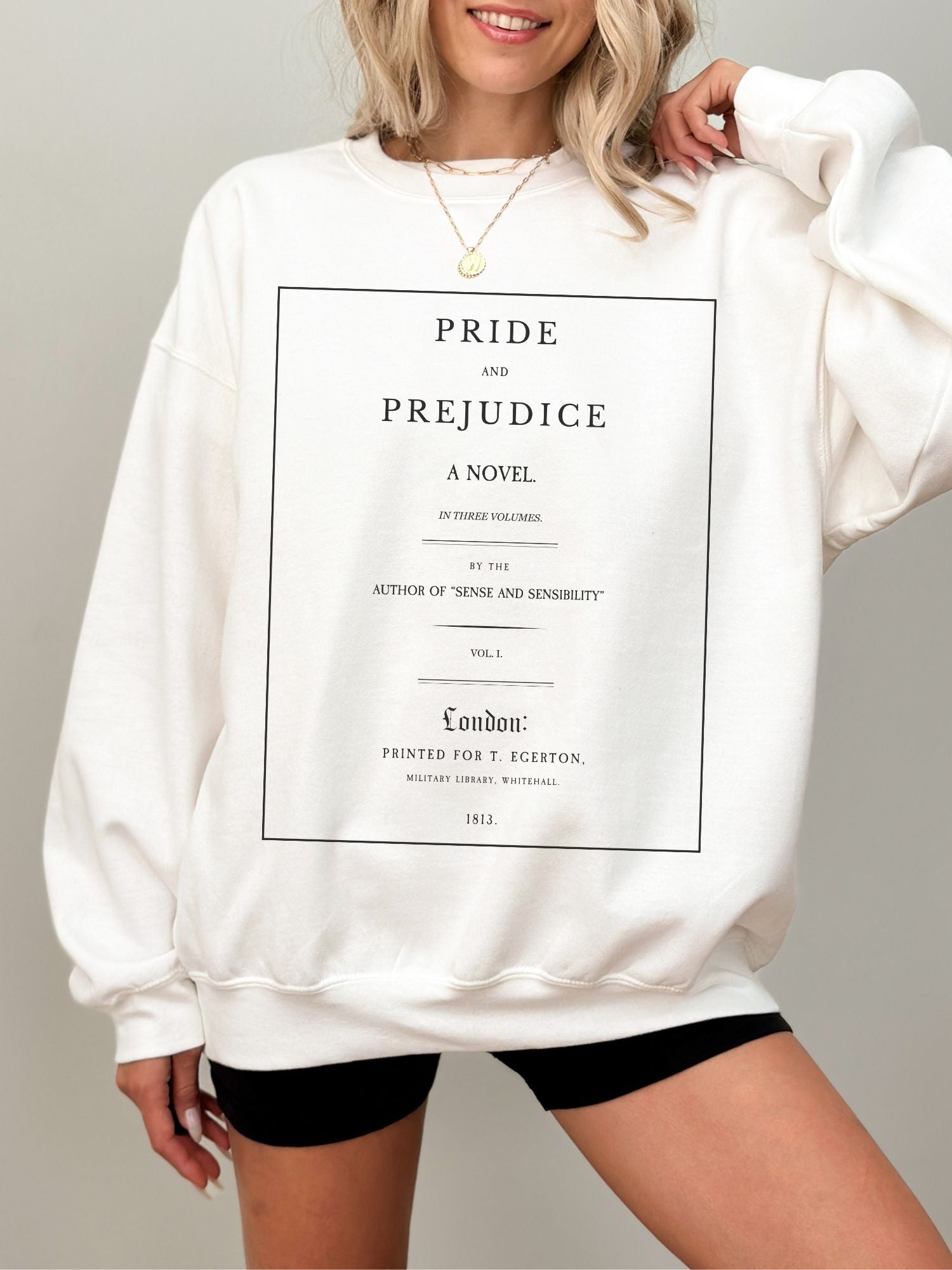 woman wearing white sweatshirt with full Pride and Prejudice title page text design from 1813