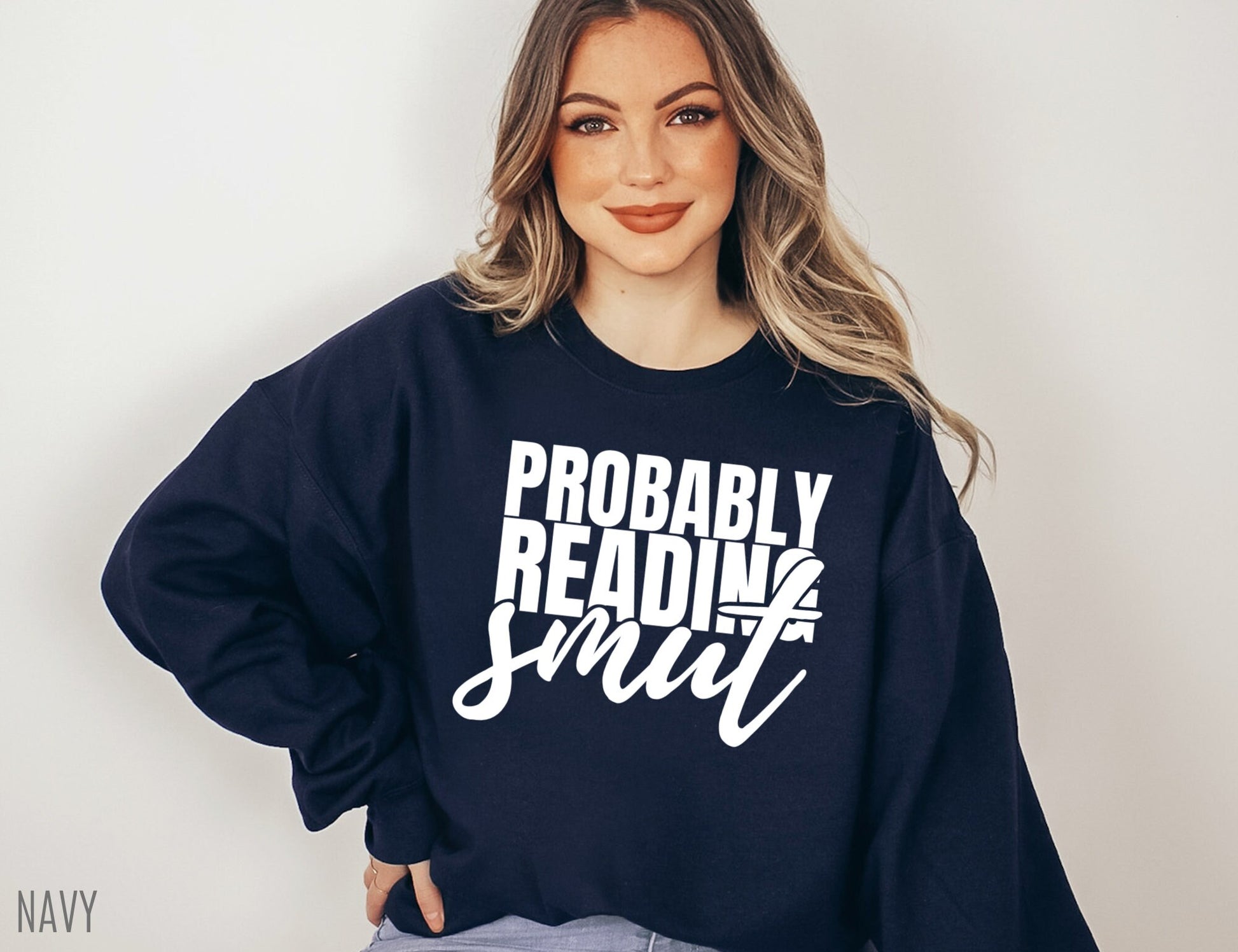 woman wearing navy Probably Reading Smut sweatshirt smiling with hand on hip