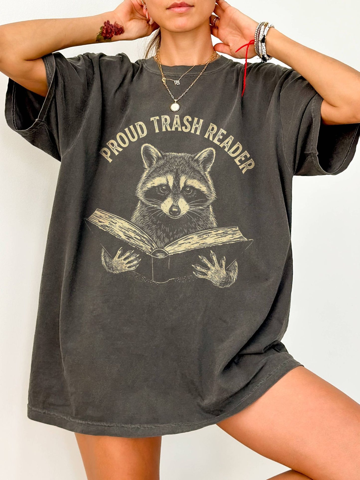 Person wearing a gray oversized t-shirt with 'overstimulated' text on a white background