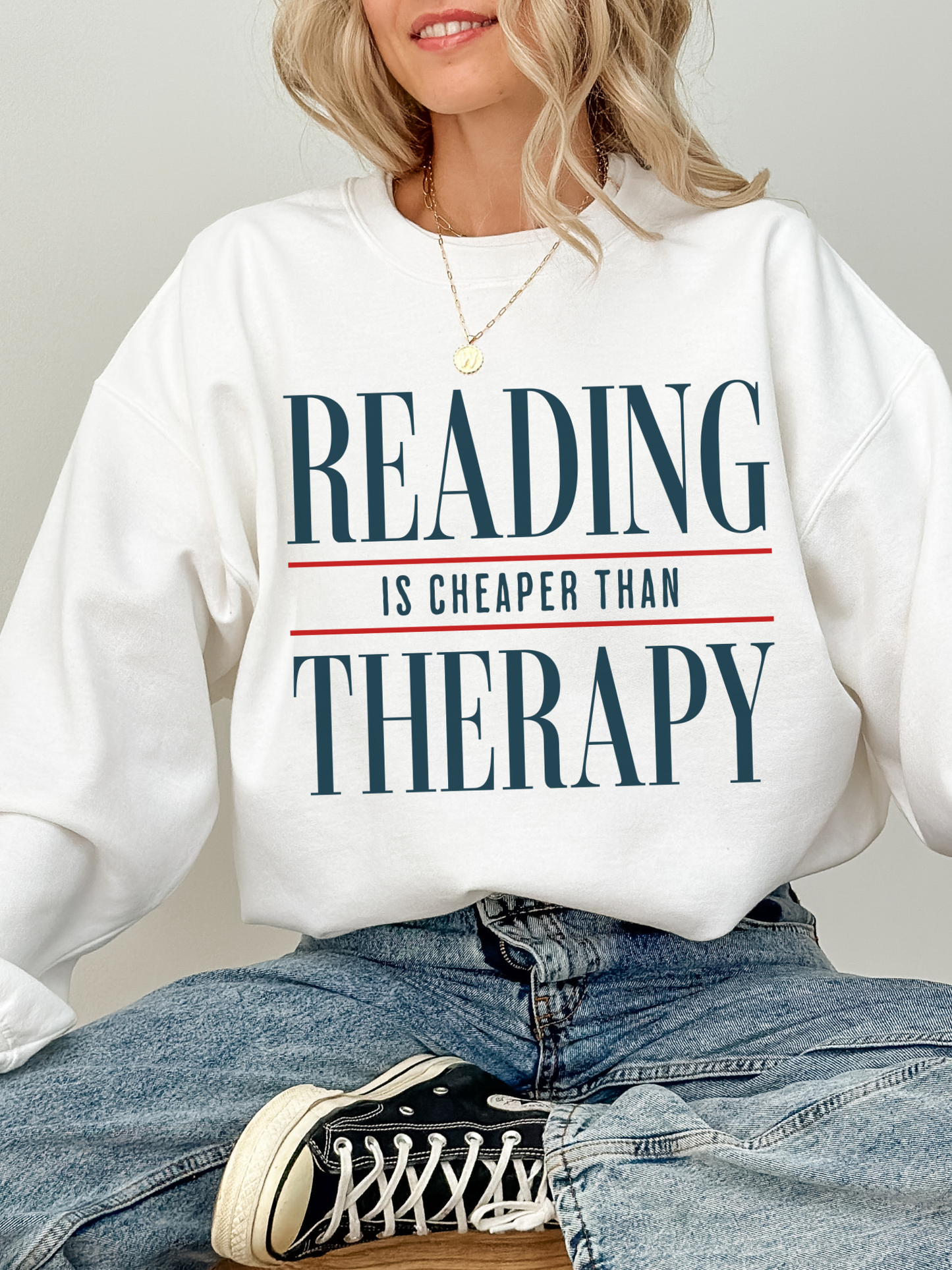 white oversized sweatshirt featuring reading is cheaper than therapy quote for readers bookworms and cozy reading aesthetic