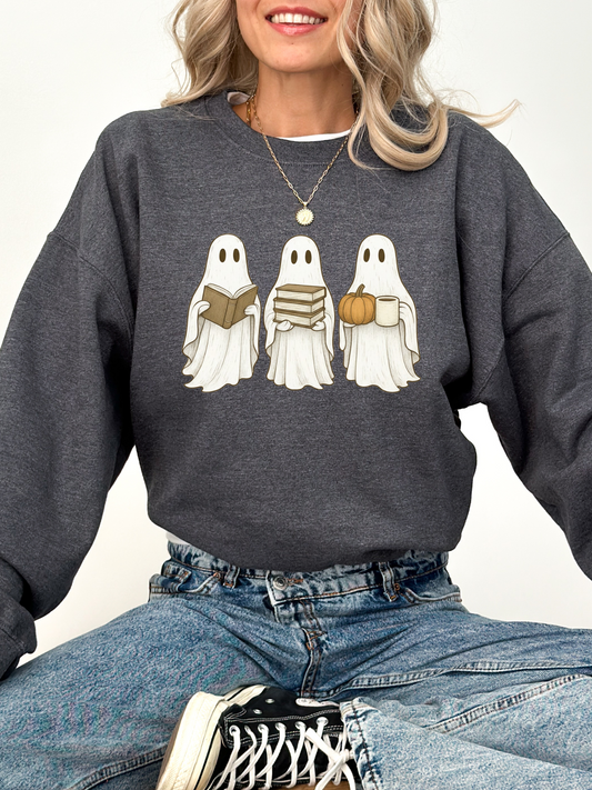woman in a dark grey sweatshirt with three illustrated bookish ghosts, each holding fall-themed reading props