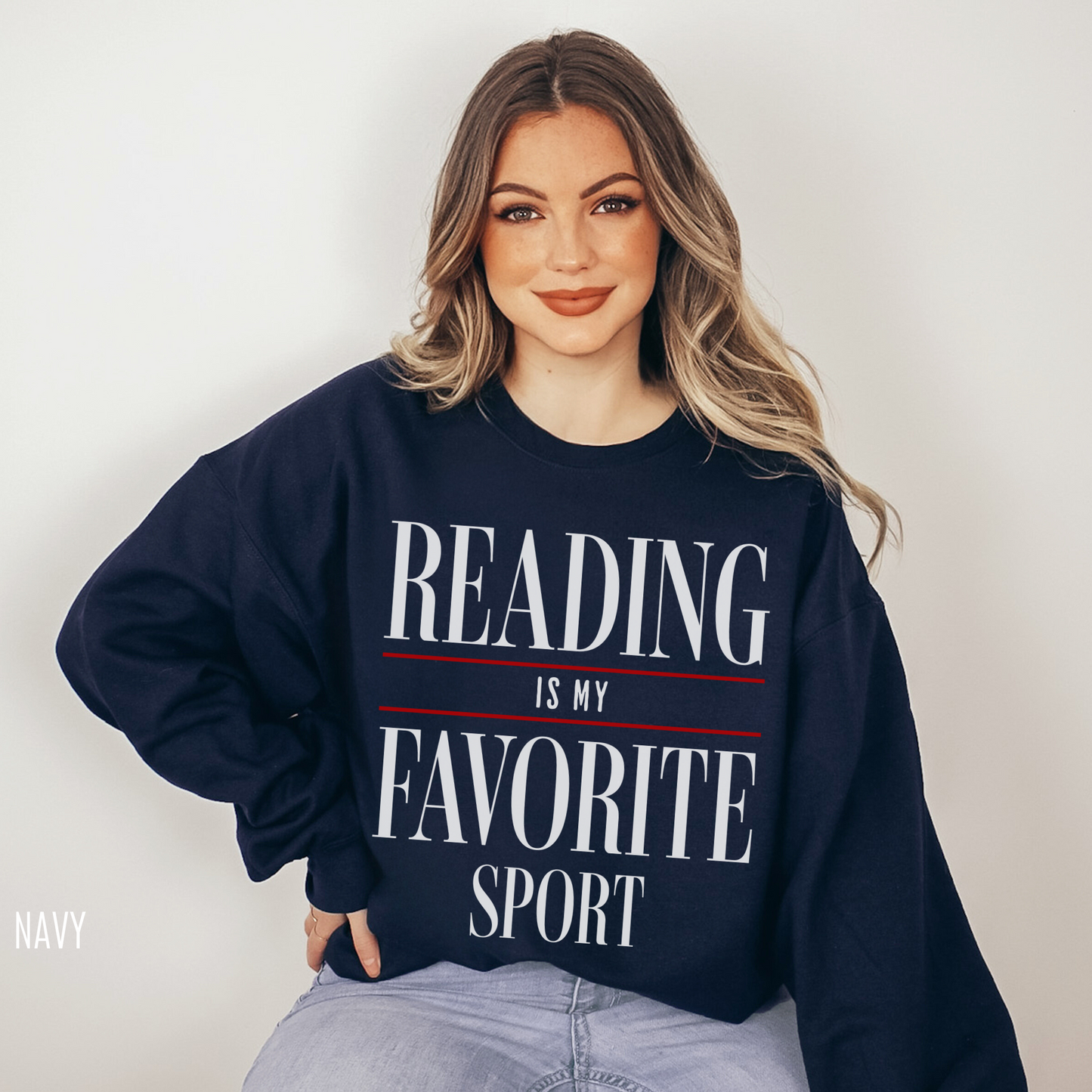 woman in navy reading is my favorite sport sweatshirt sitting on floor with relaxed bookish vibe