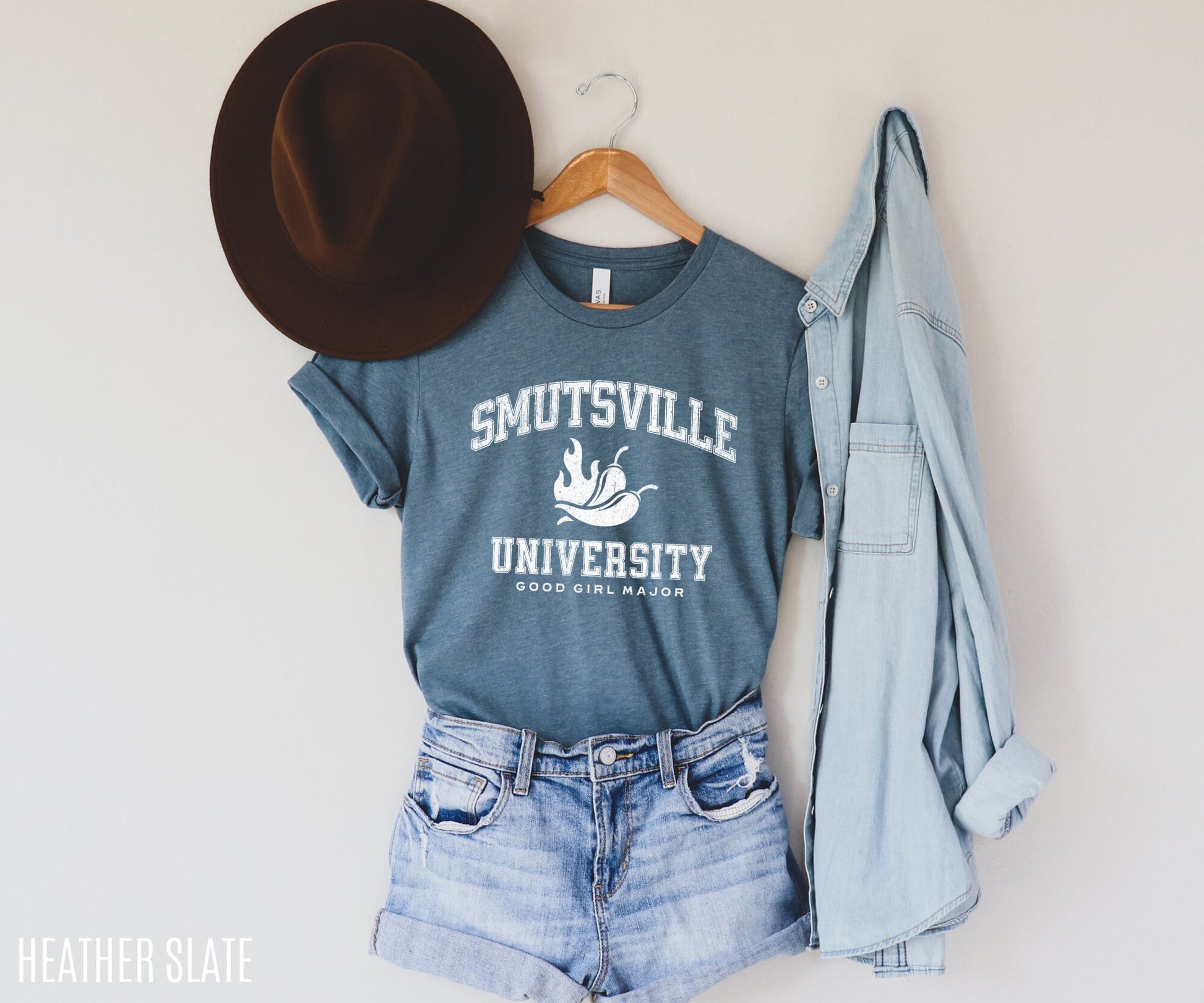 heather slate Smutsville University shirt hanging with rolled sleeves, styled with denim shirt and brown hat