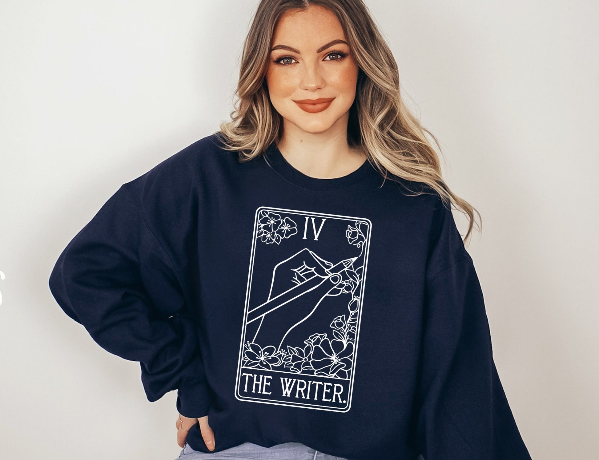 woman in navy fantasy writer sweatshirt with magical tarot card illustration and floral border