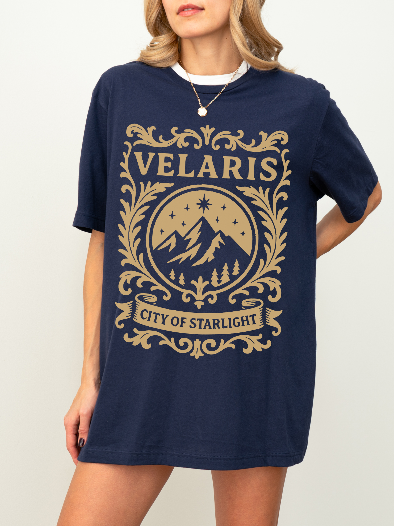 woman in a navy shirt with tan Velaris City of Starlight design inspired by ACOTAR fantasy book series