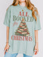 Bay Comfort Colors shirt featuring an All Booked for Christmas design with a Christmas tree made from stacked vintage books, evergreen branches, red and gold ornaments, berries and a gold star, festive bookish Christmas shirt for readers