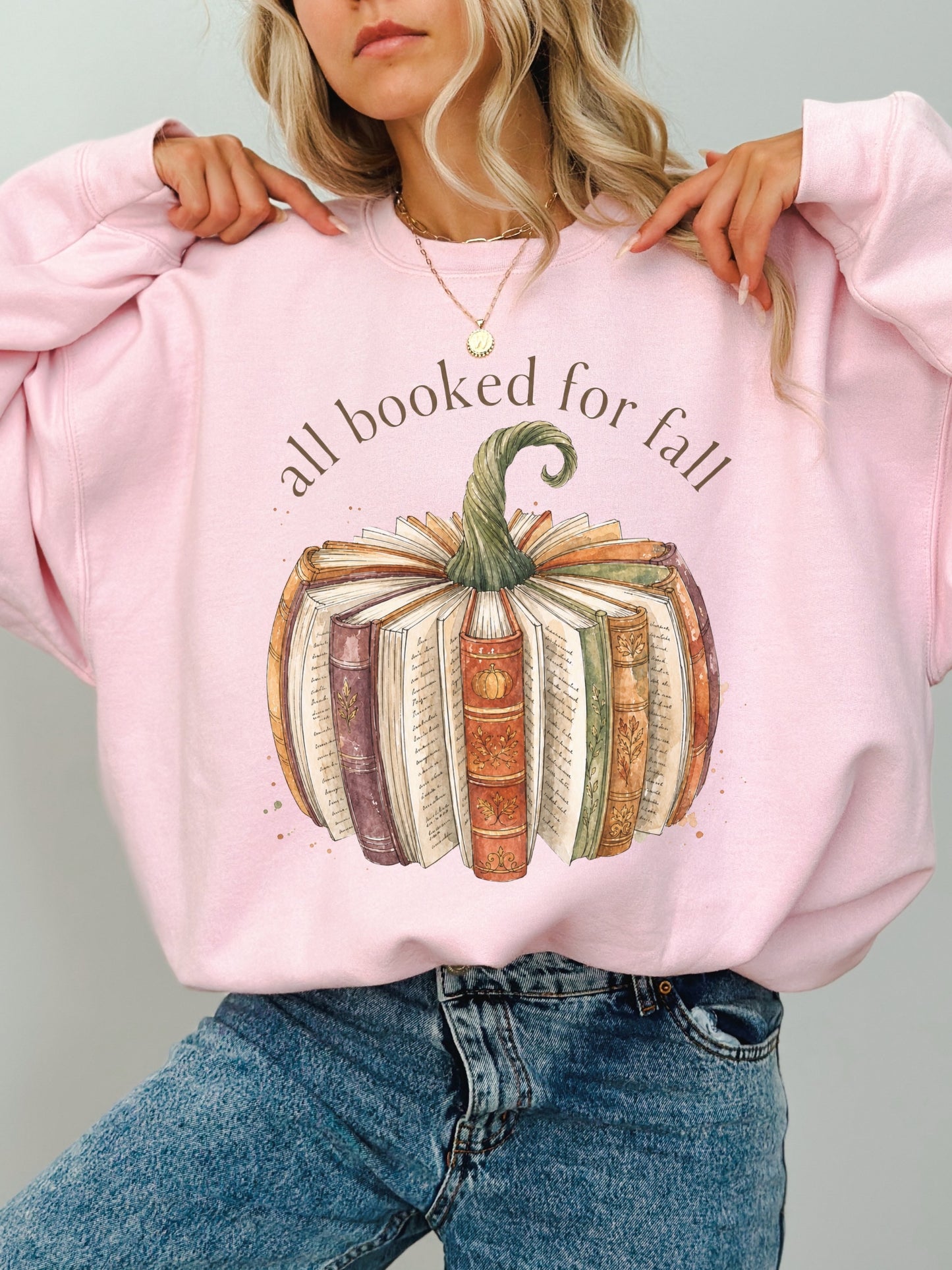 All Booked for Fall book lover Gildan sweatshirt in light pink featuring a vintage book pumpkin autumn design
