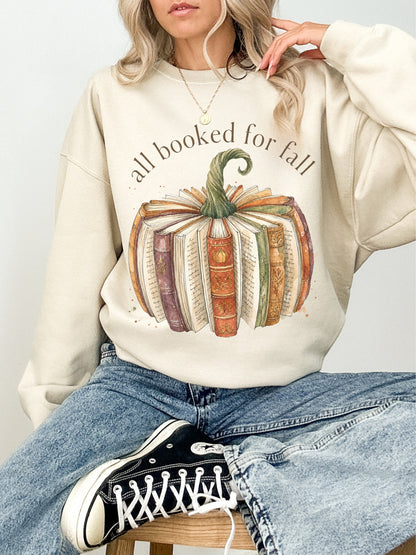 All Booked for Fall cozy reading Gildan sweatshirt in sand featuring a pumpkin made from vintage books