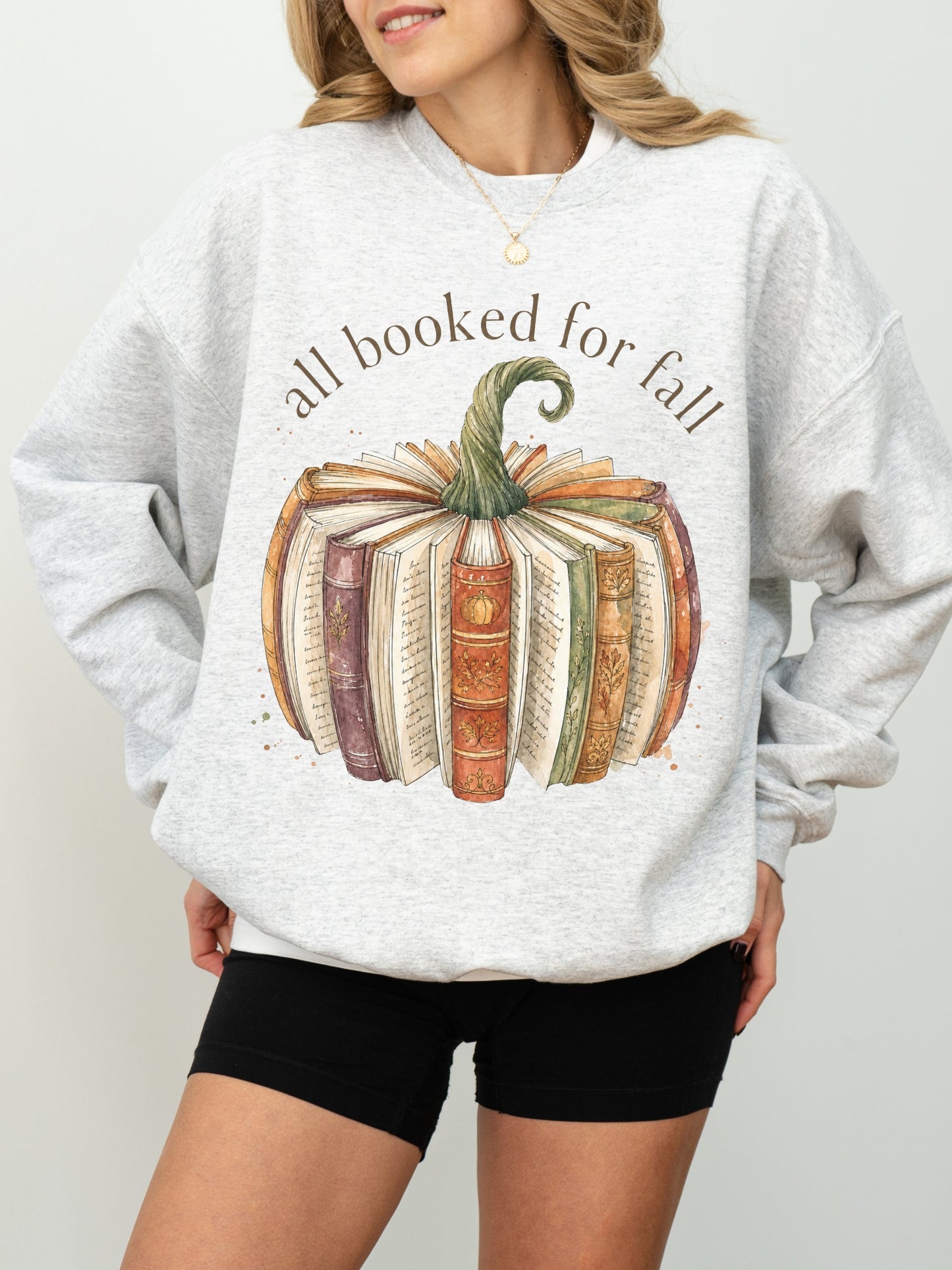 All Booked for Fall fall reading Gildan sweatshirt in ash featuring a watercolor pumpkin made from vintage books