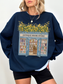 Woman wearing a navy blue sweatshirt with a vintage bookstore design featuring open doors, bookshelves, and yellow flowers styled with black shorts in a casual look