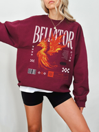 Maroon crewneck sweatshirt featuring bold phoenix fire design and Bellator fantasy text. Model standing with arm extended in front of light background, wearing layered tee and necklace.

