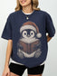 Model wearing a True Navy Comfort Colors bookish shirt featuring a cozy Christmas penguin wearing a Santa hat and reading a book