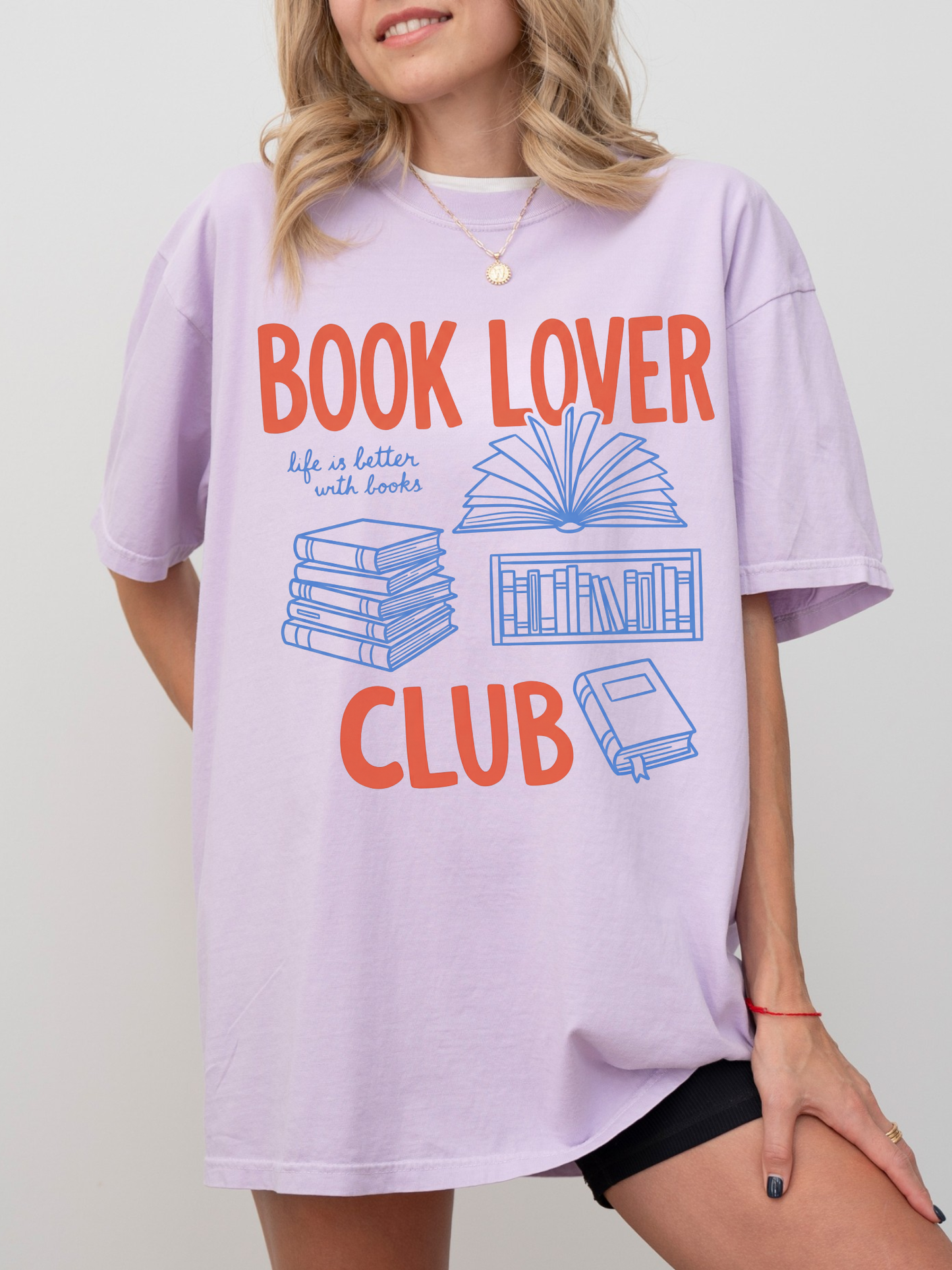 woman wearing a lavender comfort colors t shirt with book lover club design and book graphics