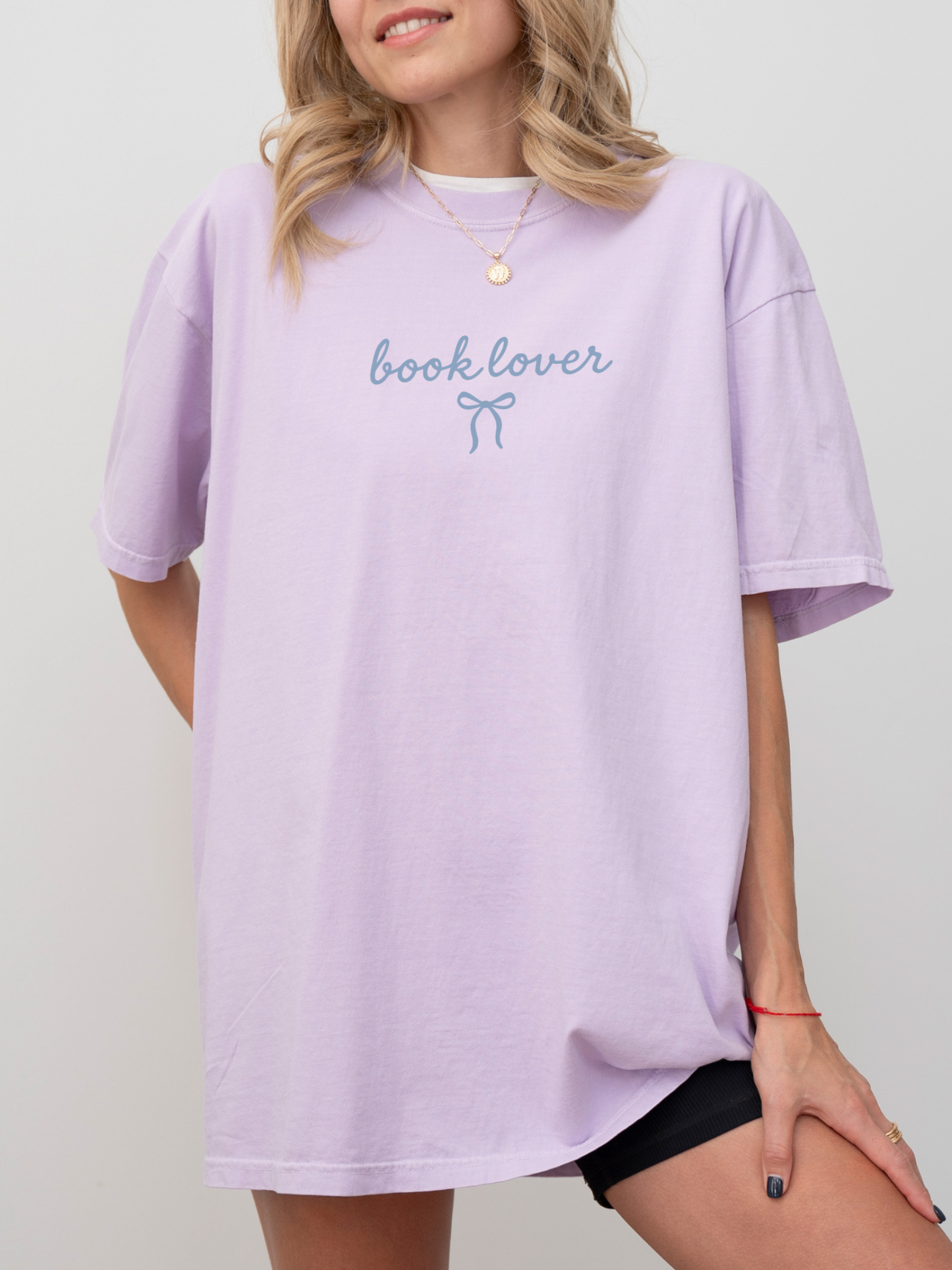 woman in lilac purple book lover t-shirt with small bow graphic