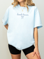pastel blue book lover shirt with bow worn by woman with blonde hair`