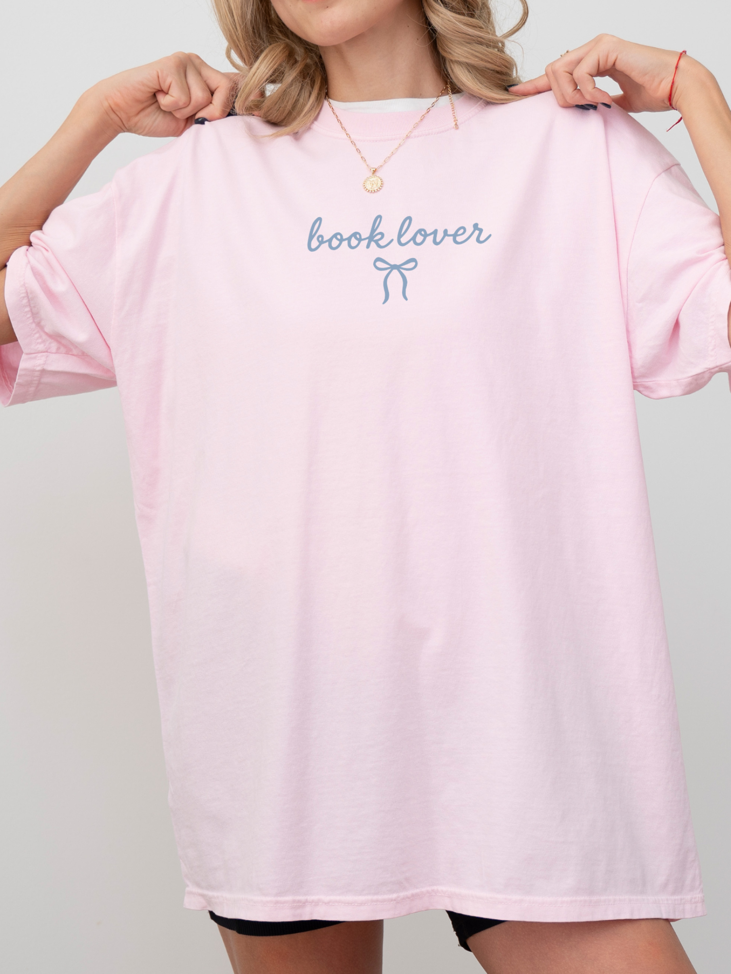 woman in oversized pink book lover tee with dainty bow design