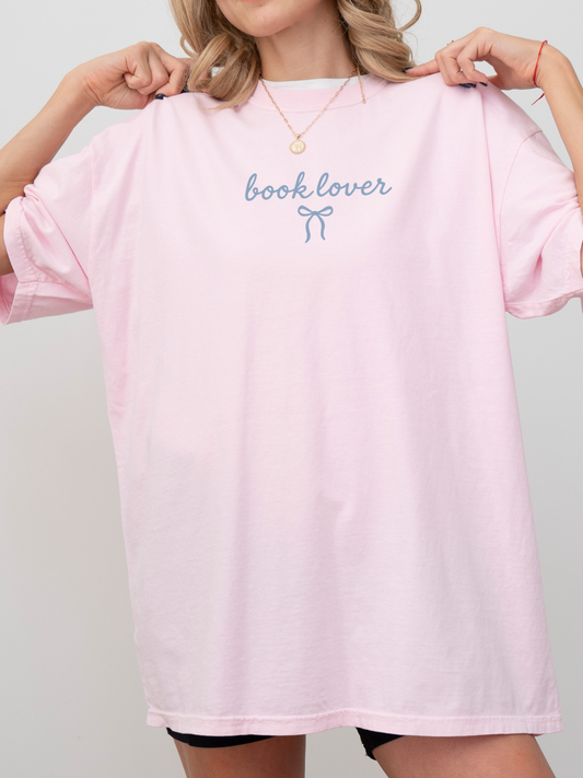 woman in oversized pink book lover tee with dainty bow design