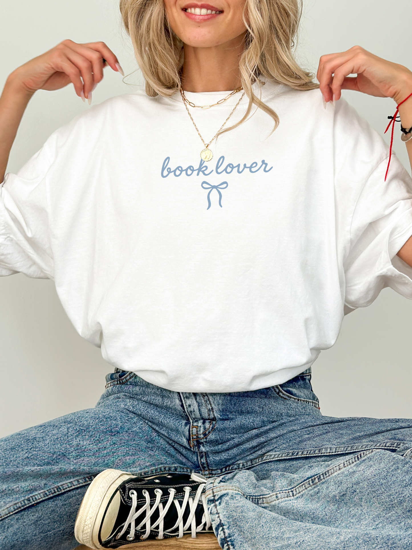 cozy white book lover tee with blue lettering styled with jeans