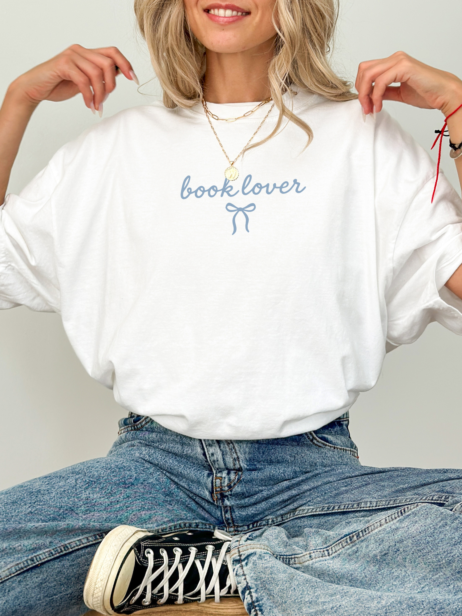 cozy white book lover tee with blue lettering styled with jeans