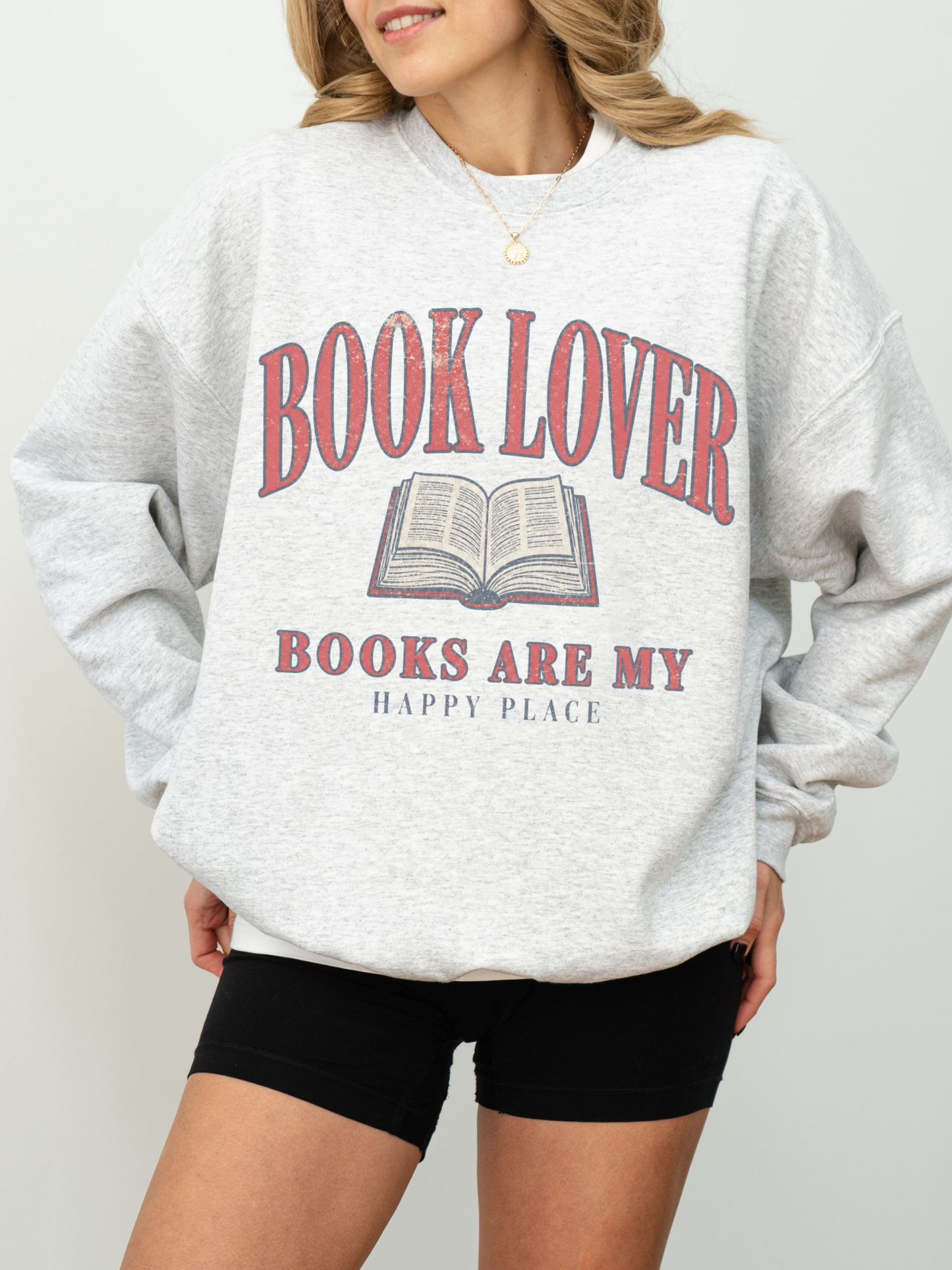 woman wearing an ash grey book lover sweatshirt with Books Are My Happy Place vintage reading design