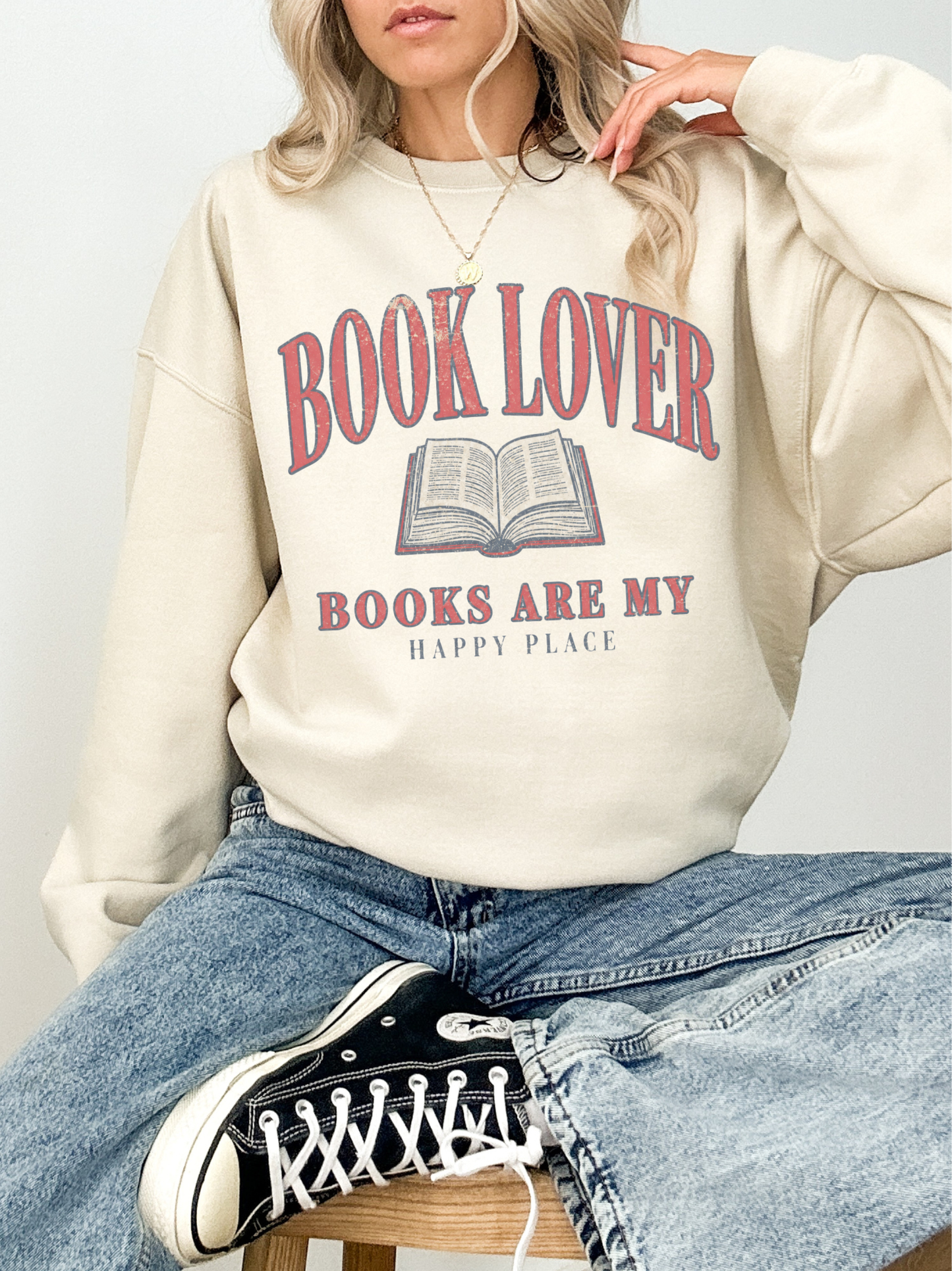 woman wearing a sand book lover sweatshirt with distressed book lover graphic and vintage reading design