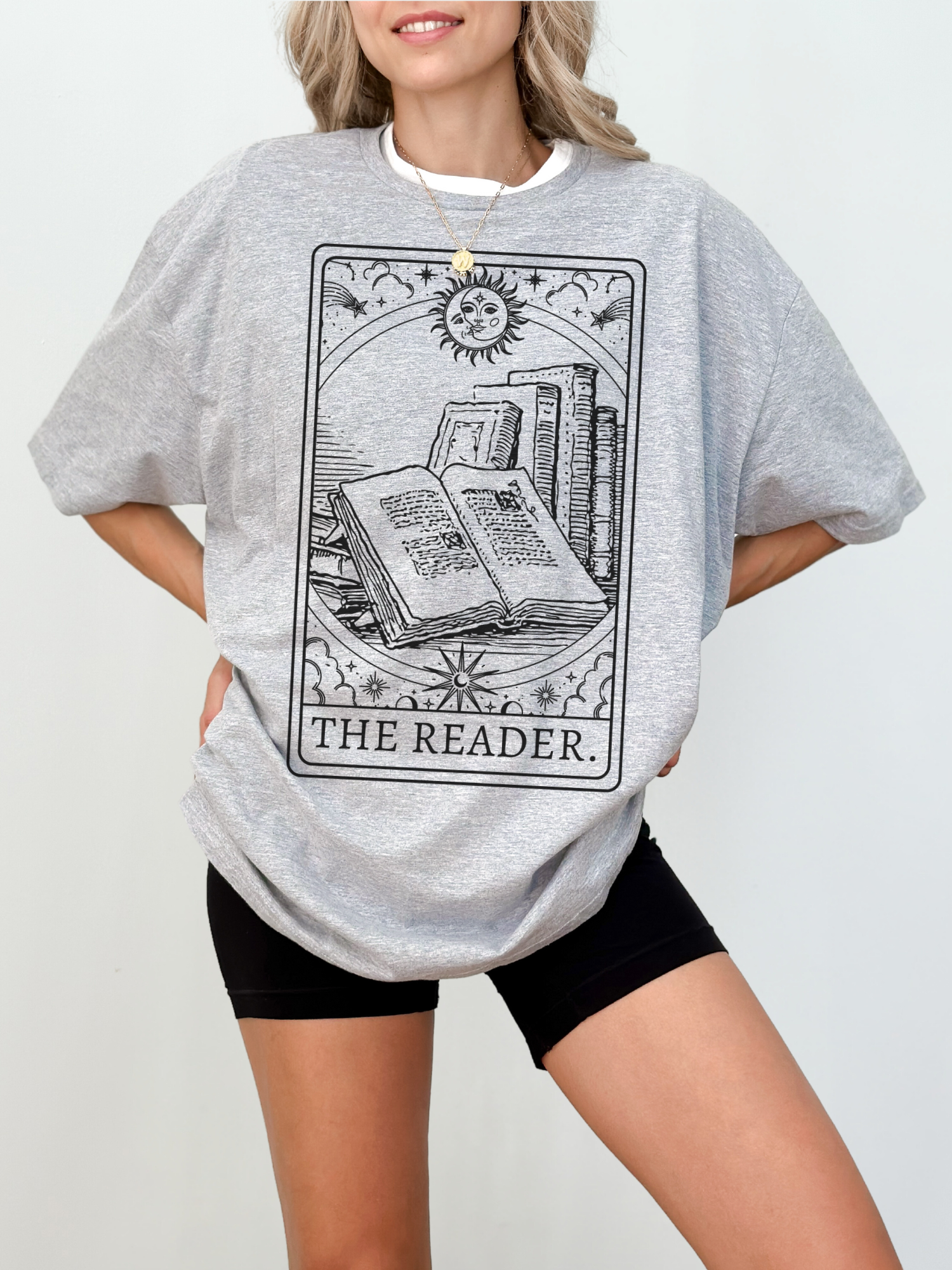 Woman wearing The Reader book tarot shirt in athletic heather grey, styled with biker shorts for a comfy bookish look