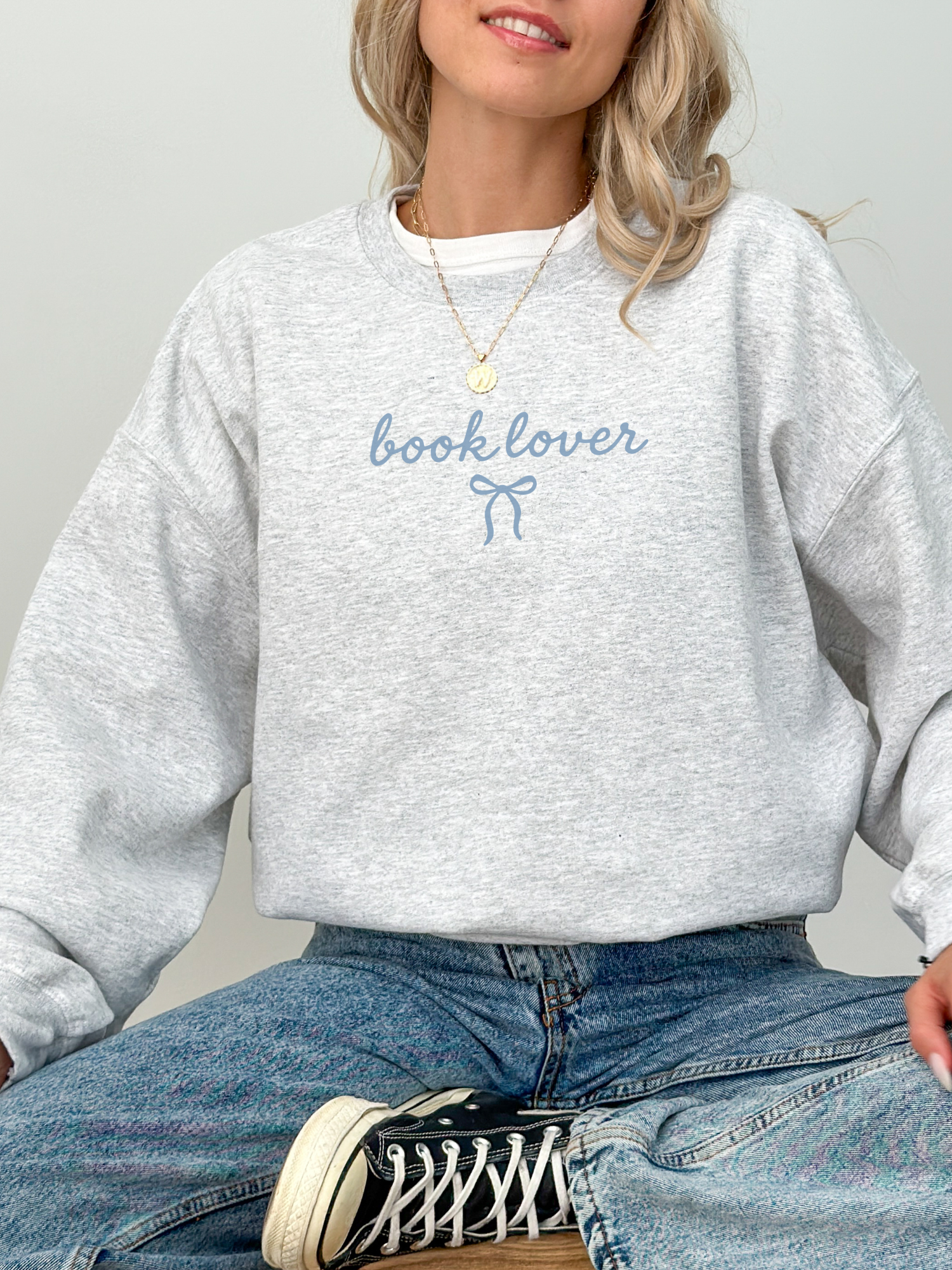 Grey crewneck sweatshirt for book lovers with dainty, styled with casual jeans and sneakers