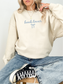 Neutral sand colored sweatshirt featuring cute bow and “book lover” script, cozy casual outfit